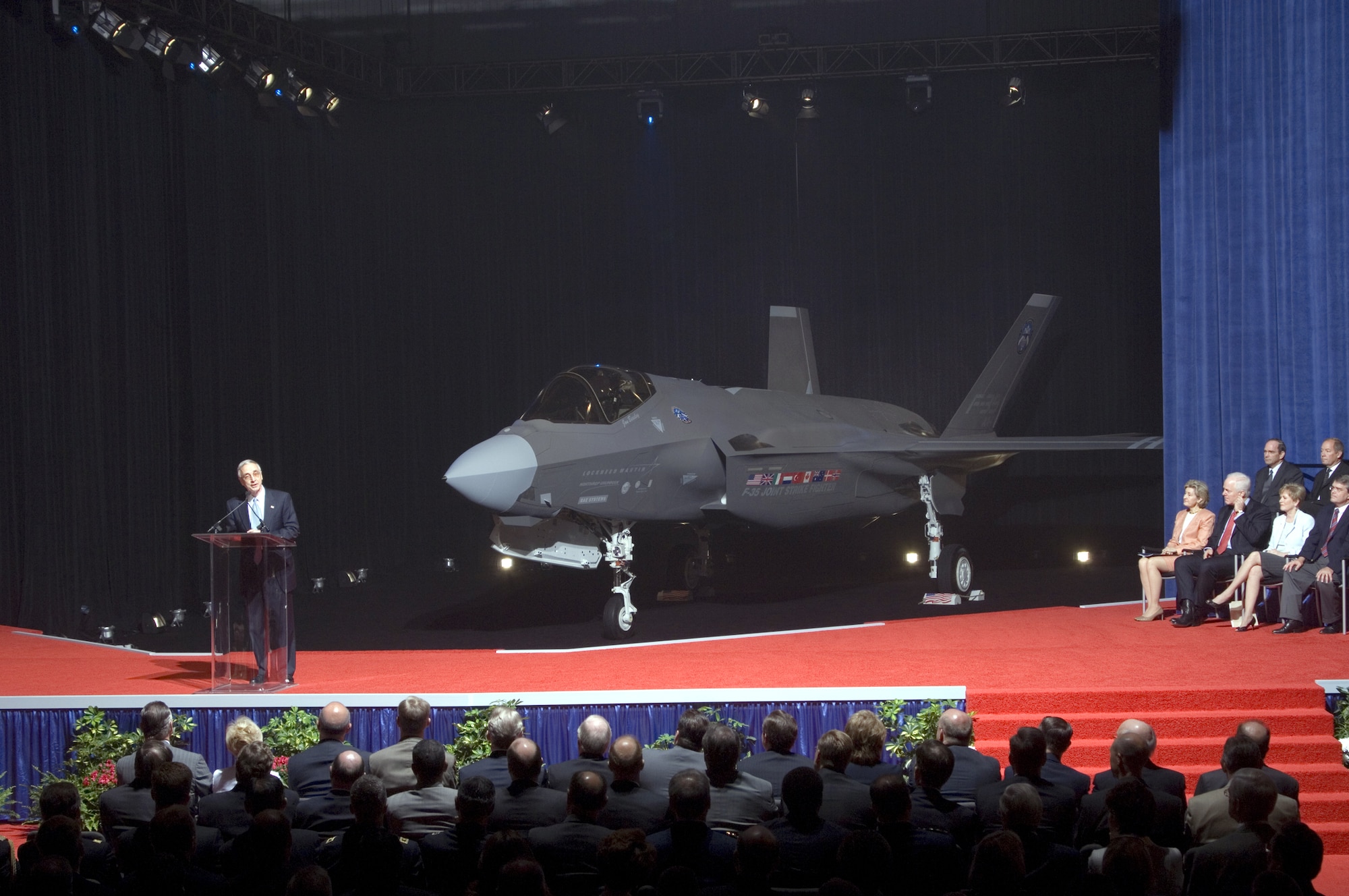 Deputy Secretary of Defense Gordon England presents the Lockheed Martin F-35 Lightning II during the inauguration ceremony at the Lockheed Martin plant in Fort Worth, Texas, on July 7.  The Lightning II is a 5th-generation, supersonic stealth fighter designed to replace a wide range of existing aircraft, including the AV-8B Harrier, A-10 Thunderbolt II, F-16 Fighting Falcon, F/A-18 Hornet and Royal Air Force Harrier GR-7 and Sea Harriers.  (Image courtesy of Lockheed Martin) 