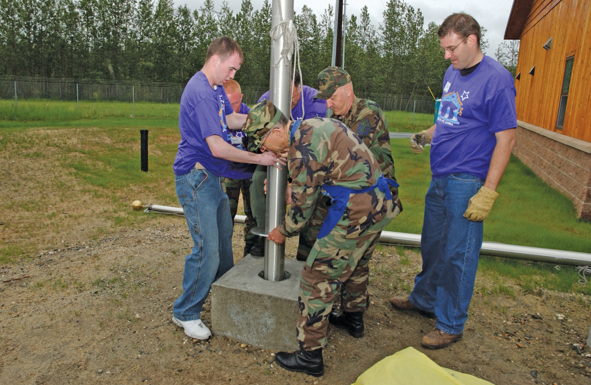 EIELSON AIR FORCE BASE, Alaska--Col. Michael Restey, front center, 354th Medical Group commander, and Master Sgt. William Croxen, back center, 354th MDG first sergeant, work with Fort Wainwright volunteers to install a flagpole at the new visitors center as Jeff Putnam, right, 354th Civil Engineer Squadron deputy commander, looks on. (U.S. Air Force photo by Airman Christopher Griffin)