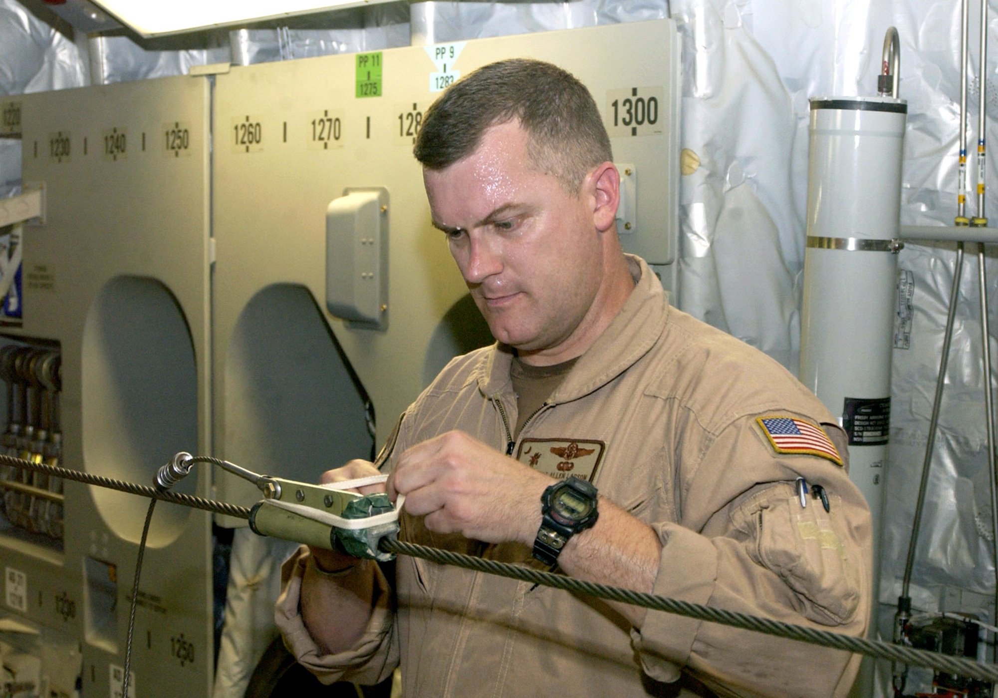 Master Sgt. Allen Larson prepares the static line for an airdrop of supplies from a C-17 Globemaster III on July 3 in Southwest Asia. Sergeant Larson is an Air Force Reserve loadmaster deployed with the 816th Expeditionary Airlift Squadron. (U.S. Air Force photo/Tech. Sgt. Chuck Marsh)