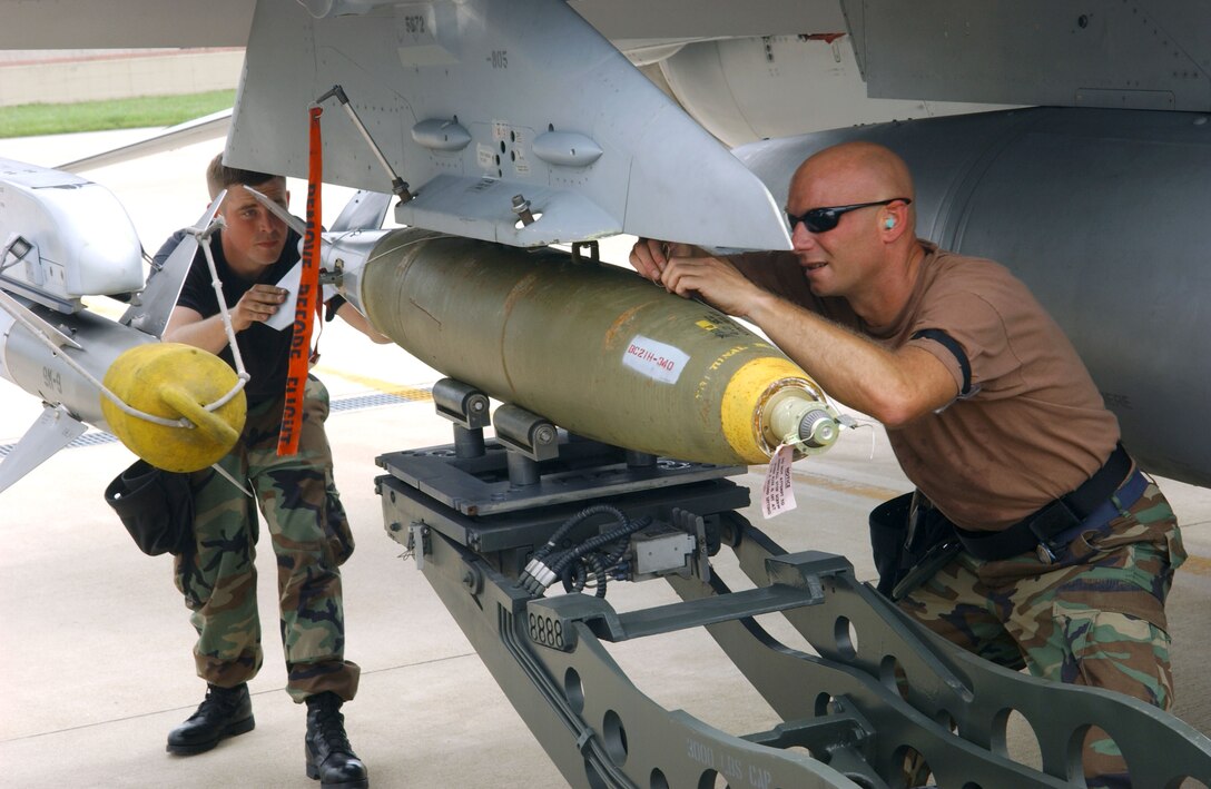 Tech. Sgt. Mike Geske, front, and Staff Sgt. Carl Valvota secure a Mark 82 bomb to an F-16 Fighting Falcon at Kunsan Air Base, South Korea, on July 5.  The aircraft is from the Montana Air National Guard's 120th Fighter Wing at Great Falls.  (U.S. Air Force photo/Tech. Sgt. Erik Gudmundson)
