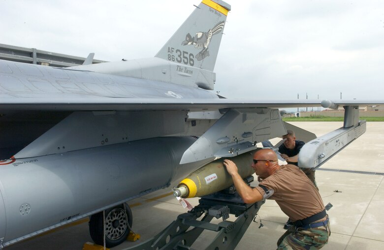 Tech. Sgt. Mike Geske, front, and Staff Sgt. Carl Valvota secure a Mark 82 bomb to an F-16 Fighting Falcon at Kunsan Air Base, South Korea, on July 5.  The aircraft is from the New Mexico Air National Guard's 150th Fighter Wing at Albuquerque.  (U.S. Air Force photo/Tech. Sgt. Erik Gudmundson)

