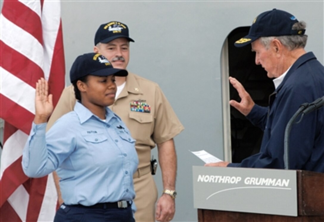 Former President George H.W. Bush reenlists U.S. Navy Petty Officer 1st Class Valarie Payton onboard the newly constructed aircraft carrier George H.W. Bush at Northrop Grumman Naval Ship Yard in Newport News, Va., July 8, 2006. 
