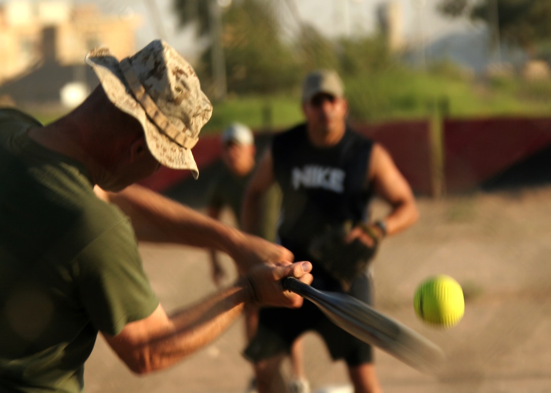 Capt. Dale H. Webster swings at a pitch thrown by Lt. Col. Gilbert C. Gonzalez at Al Asad, Iraq, July 10, during a softball game between the champions of softball league B, Marine Wing Communications Squadron 38, and the runners up in softball league A, Marine Air Control Group 38 (Reinforced). Webster is the operations officer of MWCS-38, MACG-38, 3rd Marine Aircraft Wing, and Gonzalez is the commanding officer of MACG-38 (Forward). Webster is a native of El Cajon, Calif., and Gonzalez is from San Diego.