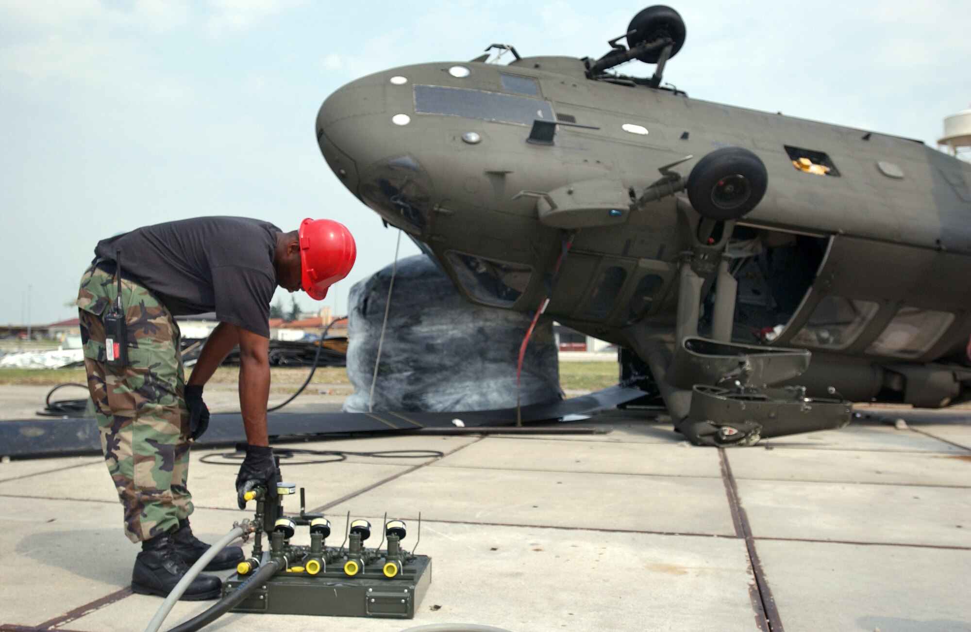 Staff Sgt. Vincent Metcalf controls the pressure on a pneumatic air bag, which will lift the nose and tail of an aircraft being stabilized at Aviano Air Base, Italy, on July 6. The aircraft suffered damage after a severe thunderstorm with wind gusts that measured up to 82 knots. The storm tore through Aviano on June 29, and caused basewide damage estimated at $3.5 million. Sergeant Metcalf is assigned to the 31st Maintenance Squadron. (U.S. Air Force photo/Airman Liliana Moreno) 
