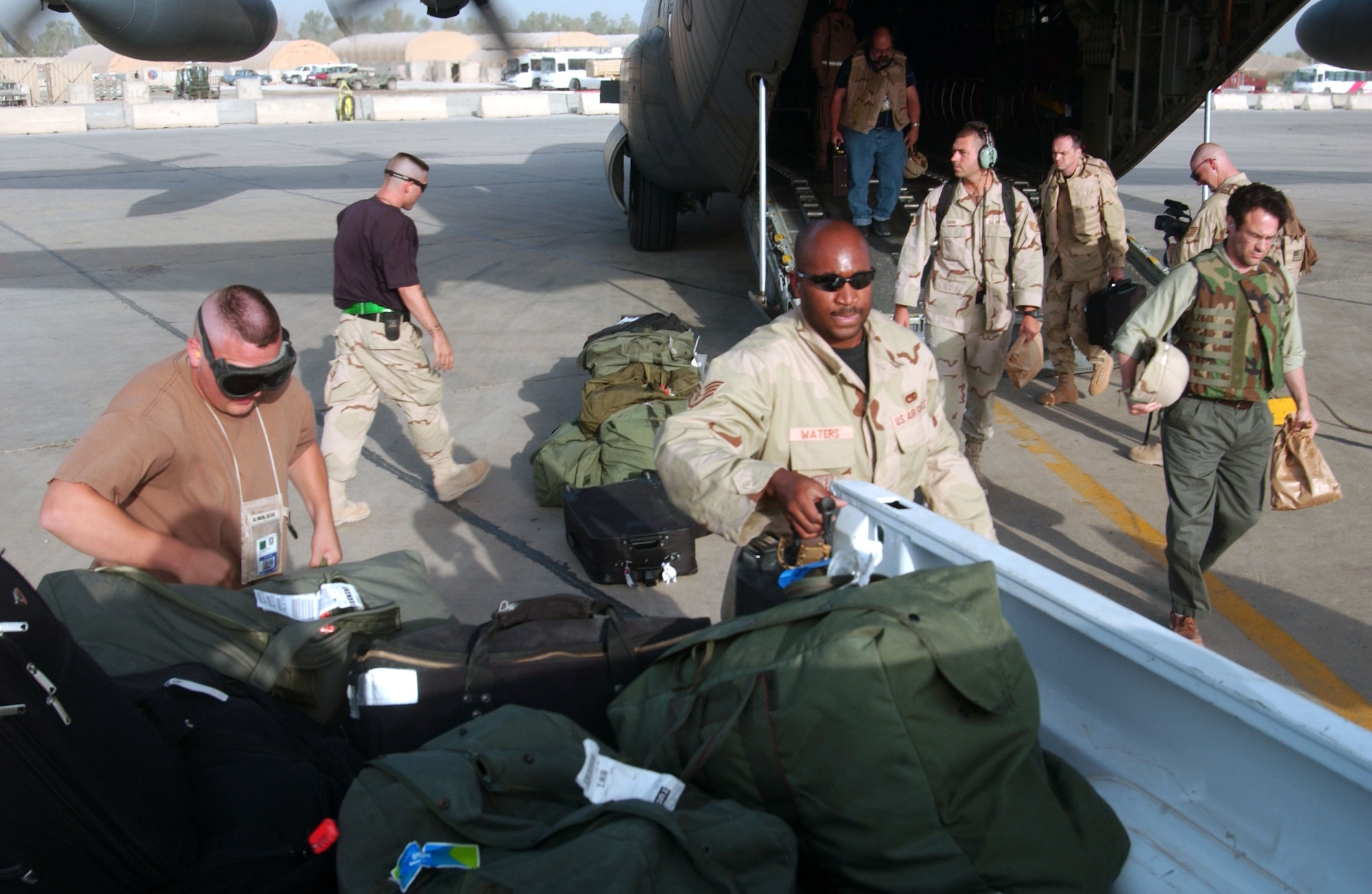 Airman guide cargo and passengers onto a C-130 Hercules at Sather Air Base, Iraq, on July 4. (U.S. Air Force photo/Master Sgt. Jonathan F. Doti) 
