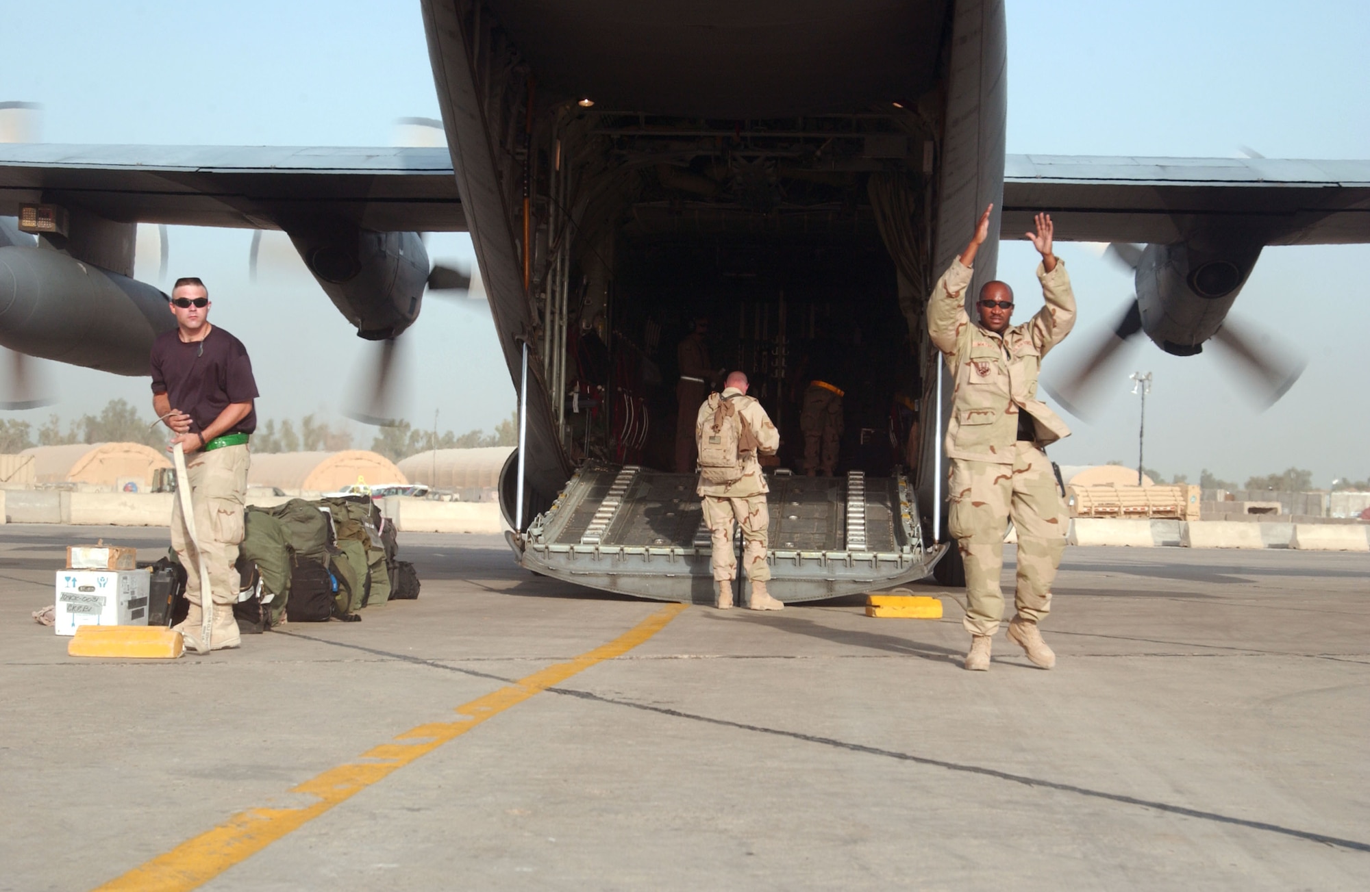 Airman guide cargo and passengers onto a C-130 Hercules at Sather Air Base, Iraq, on July 4. (U.S. Air Force photo/Master Sgt. Jonathan F. Doti)