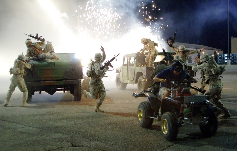 Airmen filling the roles of extras on the set of the movie "Transformers" run for cover while a camera crew on a four-wheeler captures the action during filming at Holloman Air Force Base, N.M., on May 31. The movie is scheduled for release in July 2007. (U.S. Air Force photo/Tech. Sgt. Larry A. Simmons)
