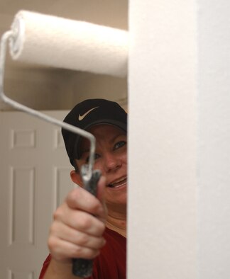 Tech. Sgt. Susanna Voorhies, from the 91st Operations Support Squadron at Minot Air Force Base, N.D., rolls a coat of paint on in a house in Biloxi, Miss. Thirty students from the Keesler Air Force Base NCO Academy volunteered more than 250 hours to help rebuild three homes in Biloxi that were damaged by Katrina in 2005.