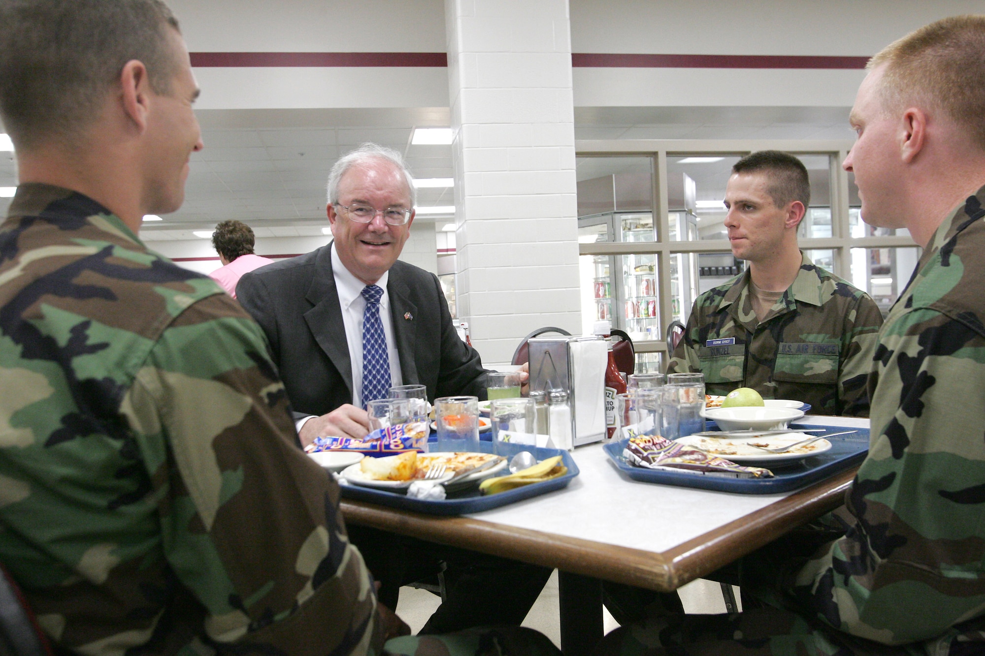 LACKLAND AIR FORCE BASE, Texas (AETCNS) Secretary of the Air Force Michael W. Wynne has lunch with fifth week basic trainees at the 326th Training Squadron here June 2. Airman Basic Bradford Herzog (left) and Airman Basic Bradley Cline are from flight 437, and Airman Basic Jacob Runzel is element leader for flight 438.