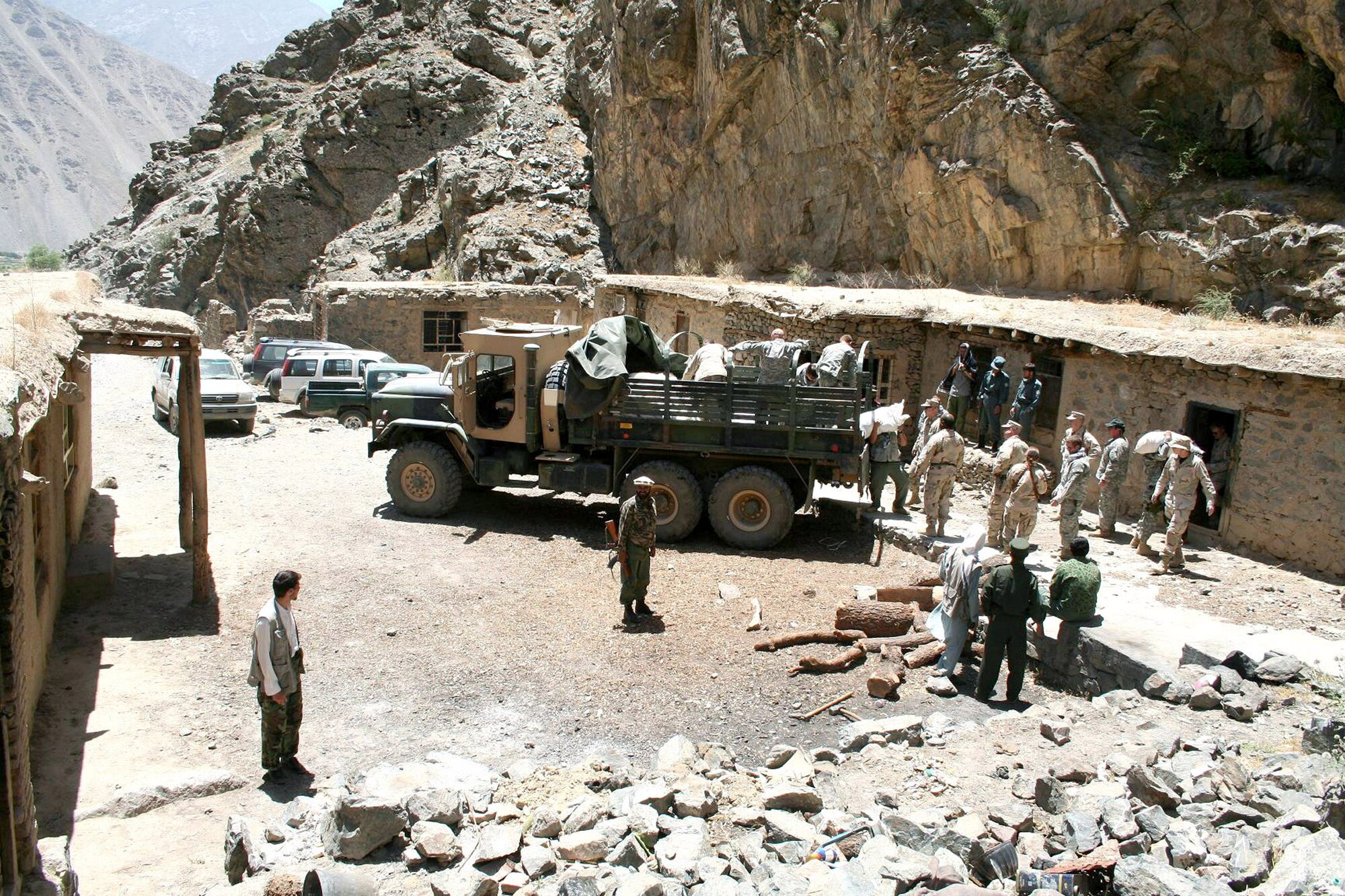 Members of the Panjshir Provincial Reconstruction Team and the Army's 405th Civil Affairs Battalion unload humanitarian assistance supplies at the Afghanistan National Police Station in the Parandae District on Saturday, July 8. The team delivered more than three tons of food to 240 families, who are beginning to run out of food from last year's harvest. Elders from the Parandae District requested the assistance and coordinated with the PRT through the deputy governor and minister of women's affairs. (U.S. Air Force photo/Tech. Sgt. John Cumper)
