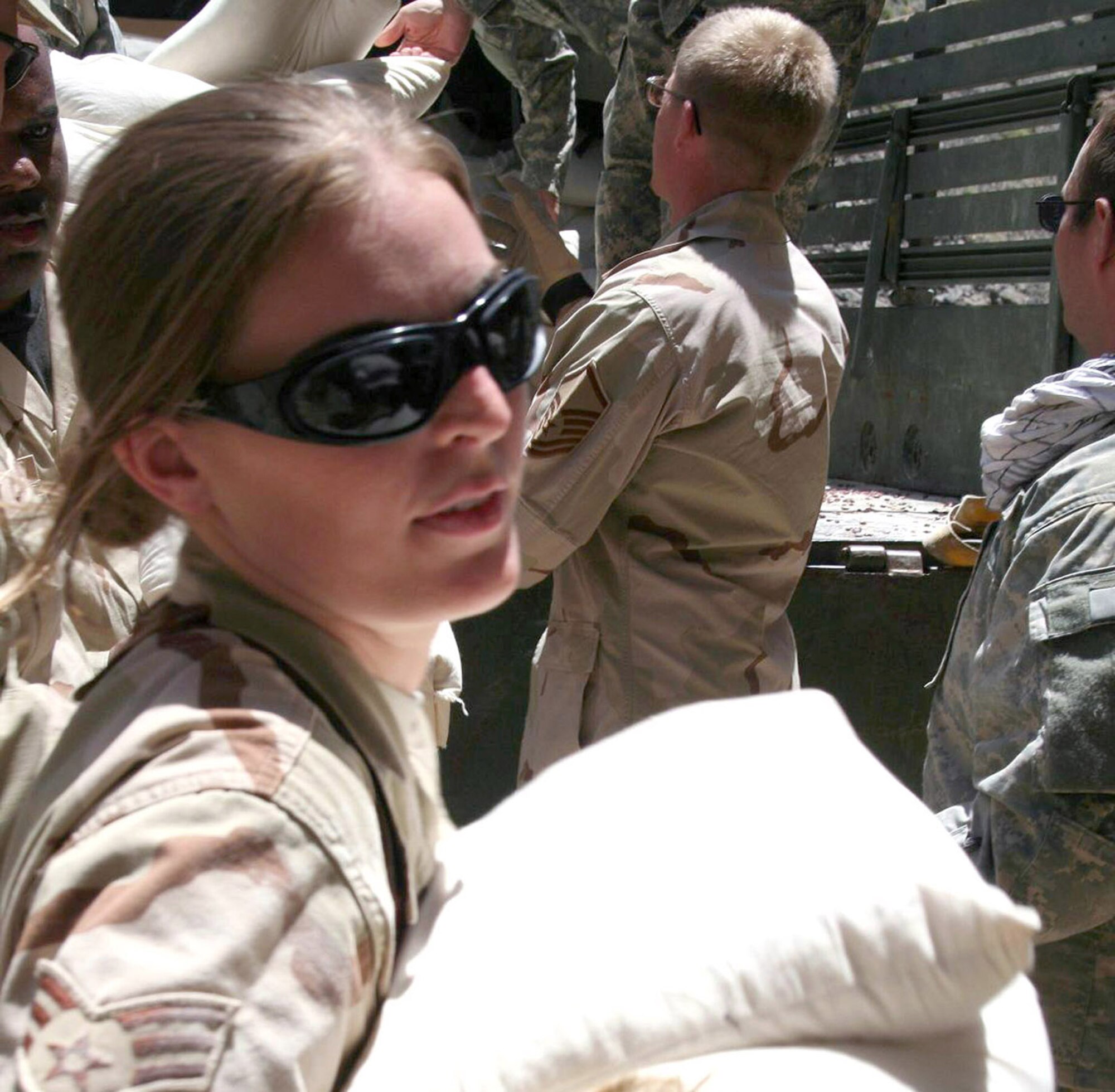 Senior Airman Melissa Laclair helps unload humanitarian supplies at the Afghanistan National Police Station in the Parandae District on Saturday, July 8. Airman Laclair is assigned to the Panjshir Provincial Reconstruction Team. The team, with help from the Army's 405th Civil Affairs Battalion, delivered more than three tons of food to 240 families, who are beginning to run out of food from last year's harvest. Airman Laclair is deployed from Columbus Air Force Base, Miss. (U.S. Air Force photo/Tech. Sgt. John Cumper)