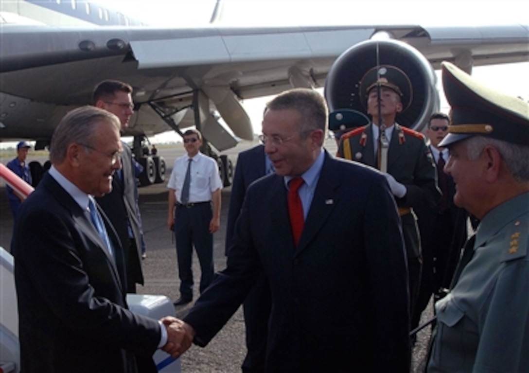 U.S. Ambassador Richard Hoagland (center) and Tajik Defence Minister Gen. Col. Sherali Khairulloyev welcome U.S. Secretary of Defense Donald H. Rumsfeld to Dushanbe, Tajikistan, on July 10, 2006. Rumsfeld traveled to Dushanbe to meet with Tajik President Emomali Rahmonov to discuss defense issues of mutual interest.