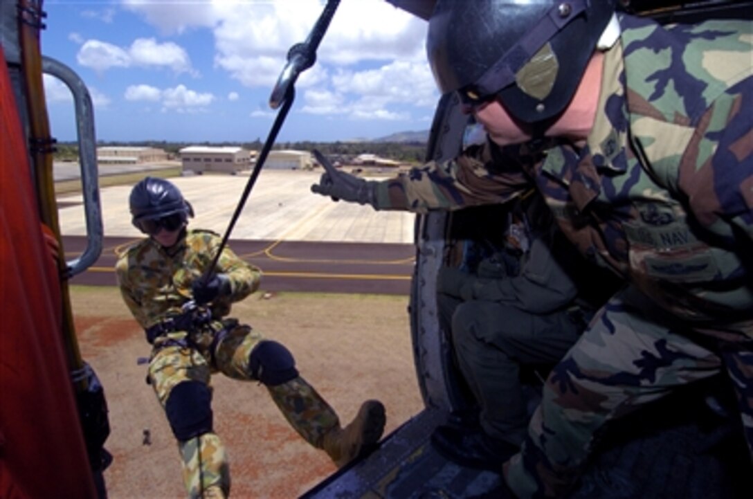 U.S. Navy Chief Petty Officer Lyle White (right) signals to Australian Able Seaman Adam Hubbard as he prepares to rappel from an HH-60H Seahawk helicopter during exercise Rim of the Pacific at Wheeler Army Airfield, Hawaii, on July 8, 2006.