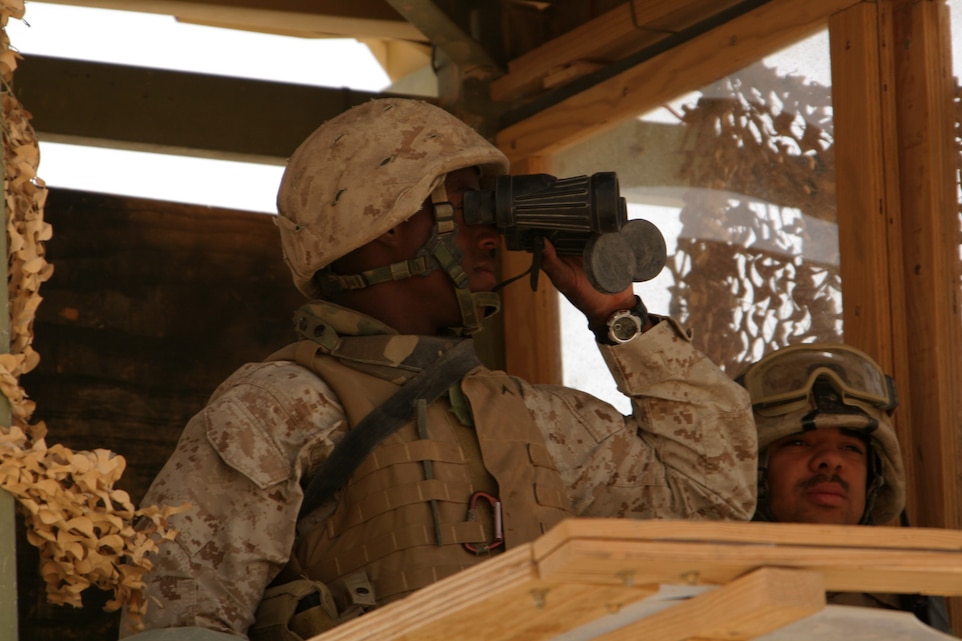 Pfc. Tony A. Peoples (left) and Cpl. Joshua R. Roy scan over the distant desert at the edge of Al Asad, Iraq, July 12. Peoples and Roy are tower sentries with 1st Platoon, Echo Company, 1st Battalion, 14th Marine Regiment, Marine Wing Support Group 37 (Reinforced), 3rd Marine Aircraft Wing. Peoples is a native of Chicago, and Roy is a Lumberton, Texas, native.