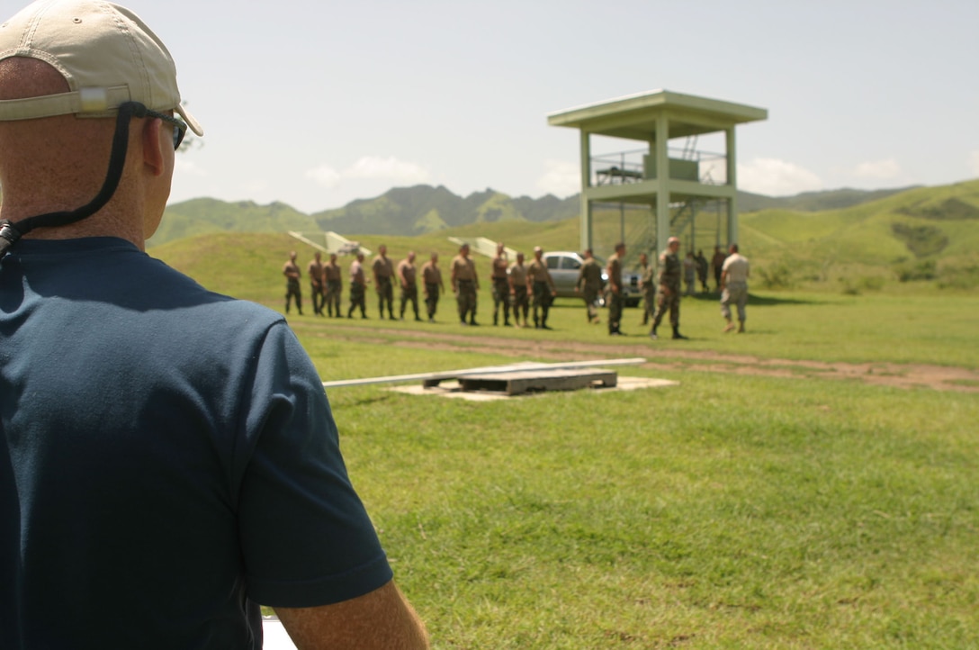 CAMP SANTIAGO, SALINAS, Puerto Rico ? (July 11, 2006)?An evaluator from Foreign Military Training Unit, Marine Corps Forces Special Operation Command, watches his Marines train soldiers from the 448th Engineer Battalion and 313th Postal Group, 65th Army Readiness Command of the Army Reserve,  during Team-5's Operational Readiness Exercise here. For their annual training, the soldiers served as students for the team which is preparing to deploy in the upcoming months to South America. (Official U.S. Marine Corps Photo by Cpl. Ken Melton)