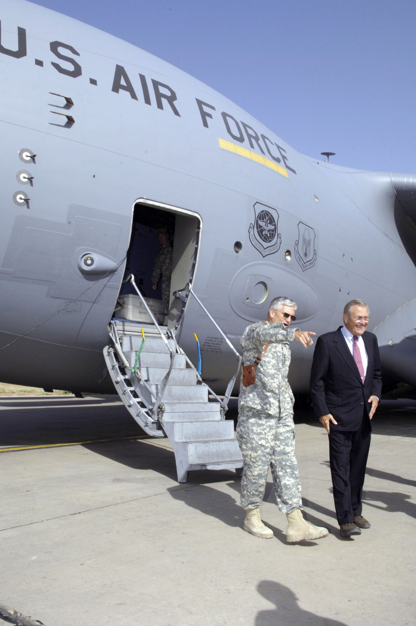 Army Gen. George W. Casey Jr. walks with Secretary of Defense Donald H. Rumsfeld as the secretary arrives at Balad Air Base, Iraq, on July 12. Secretary Rumsfeld is visiting Iraq to talk with servicemembers. General Casey is commanding general of Multi-National Forces in Iraq. (U.S. Air Force photo/Airman 1st Class Andrew Oquendo) 
