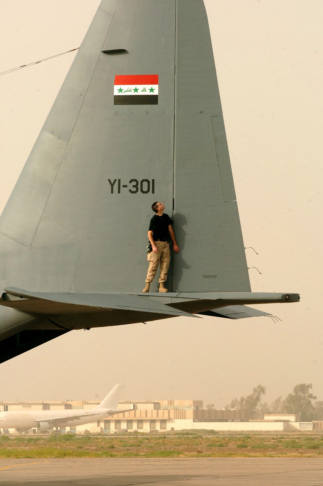 Senior Airman Jeff McCain performs a post-flight check on an Iraqi C-130 at New Al Muthana Air Base, Iraq, on July 11. Airman McCain is a member of the Coalition Air Force Transition Team working with Iraqis to rebuild their air force. He is deployed from Little Rock Air Force Base, Ark. New Al Muthana AB is located next to Sather Air Base at the Baghdad International Airport. The Iraqi Ministry of Defense formally stood up the new air base and its C-130 unit, the 23rd Squadron, in a ceremony March 7. (U.S. Air Force photo/Staff Sgt. Bryan Bouchard)