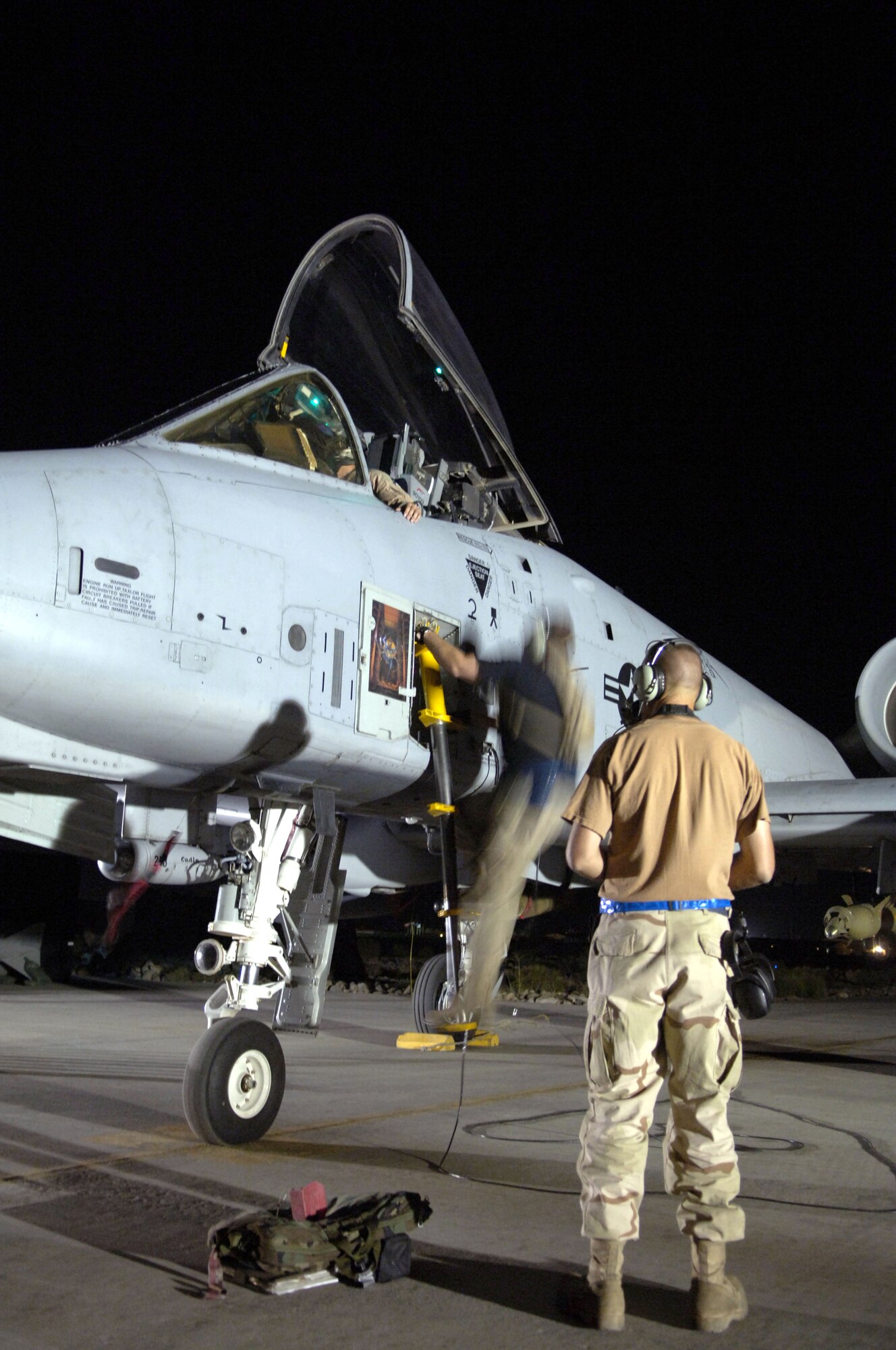 Two crew chiefs assist an A-10 Thunderbolt II pilot at Bagram Air Base, Afghanistan, after a mission July 6 in support of Operation Enduring Freedom. The A-10 is used for close-air support. The crew chiefs are assigned to the 455th Expeditionary Aircraft Maintenance Squadron. (U.S. Air Force photo/Airman 1st Class Andrew Oquendo)