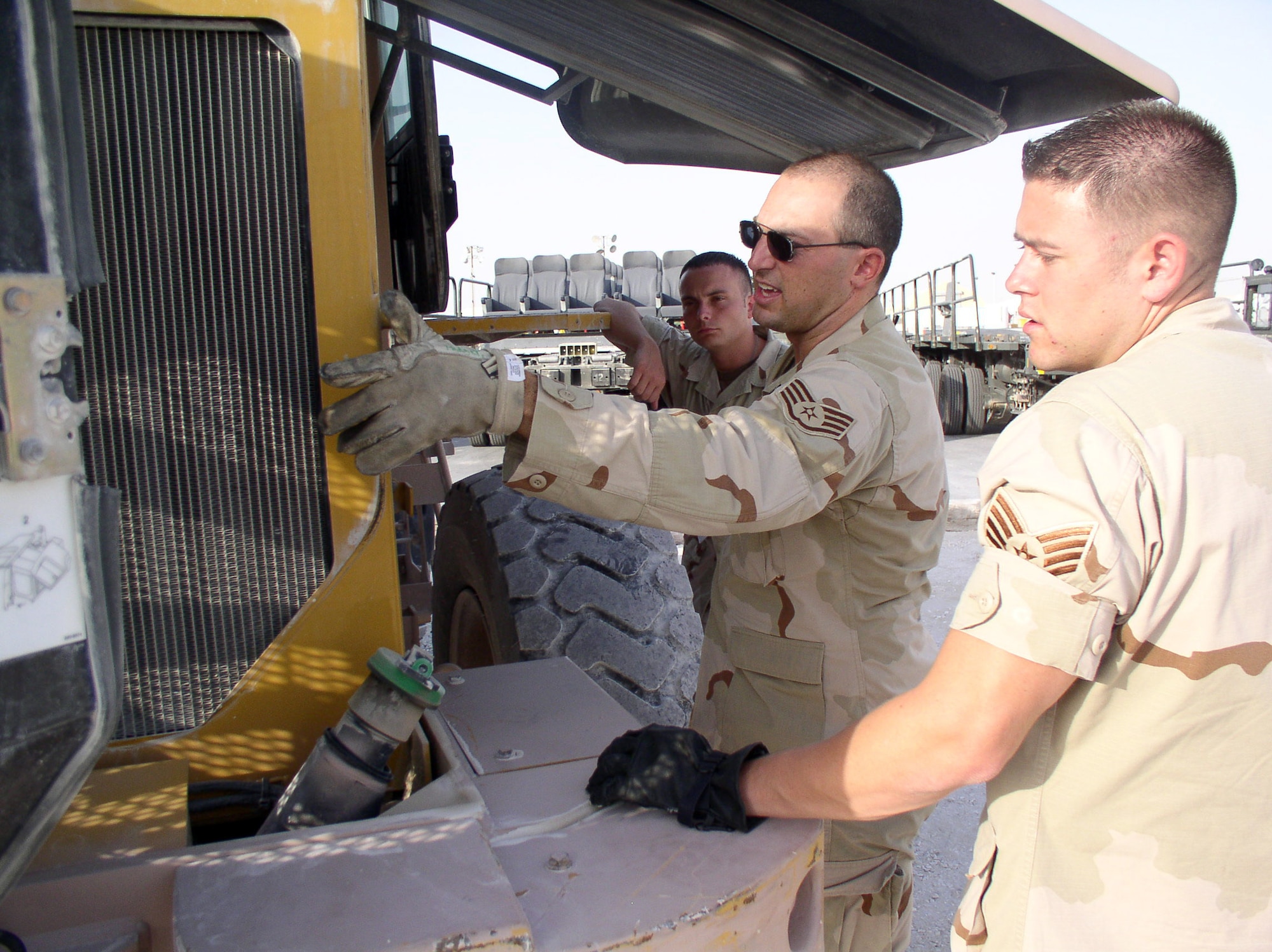 Staff Sgt. John Padget instructs Staff Sgt. Jason Gray and Senior Airman Richard Sanders in the preventative maintenance of an all-terrain forklift at a forward operating location in Southwest Asia on July 3. The Airmen are with the 379th Expeditionary Operational Support Squadron. (U.S. Air Force photo/Master Sgt. Dutch DeGroot)