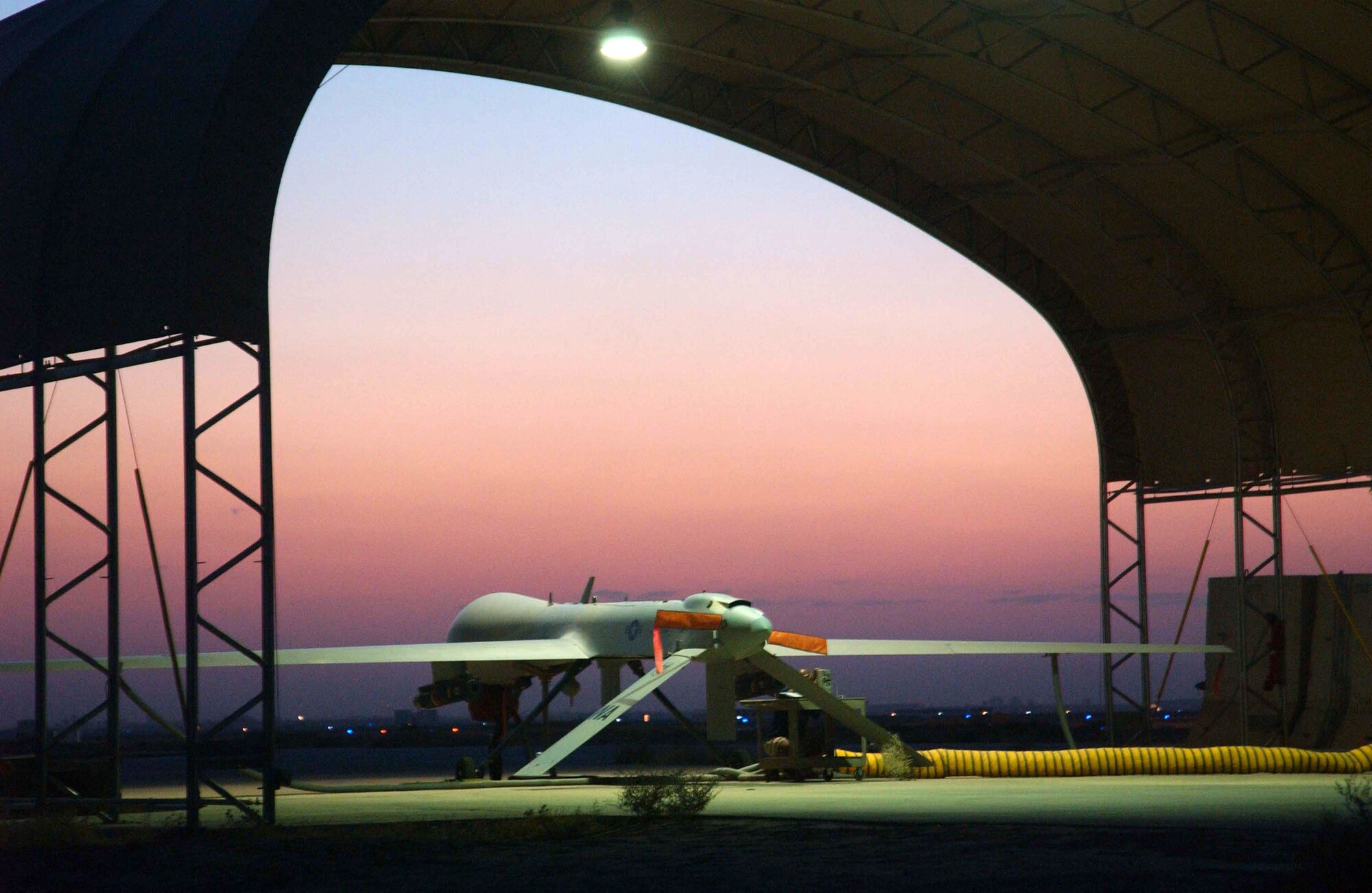 An MQ-1 Predator unmanned aerial vehicle basks in a desert sunset at Balad Air Base, Iraq, ready for nighttime operations on Sunday, July 9. Assigned to the 332nd Air Expeditionary Wing, the Predator is the most requested weapons system in the U.S. Central Command theater. Balad is home to the largest Predator operation in the world, providing real time "eyes in the skies" to ground commanders for identifying enemy activities. (U.S. Air Force photo/Master Sgt. Jonathan Doti)