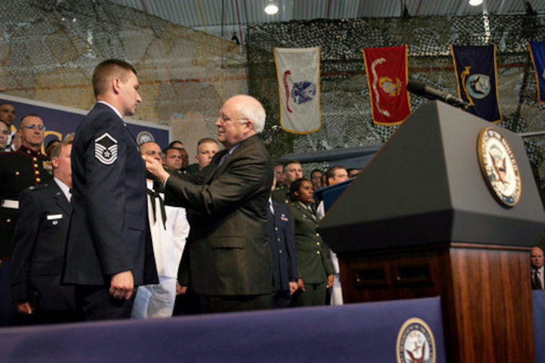 Vice President Richard B. Cheney pins the Purple Heart Medal onto Air Force Master Sgt. Henry G. Christle Jr., July 10 during a rally for the Michigan National Guard at Selfridge Air National Guard Base, Mich. Christle was wounded in action on March 23, 2004, while serving as a special operations weather team forecaster and observer Special Operations Task Force 180 in Afghanistan. White House photo by David Bohrer 
