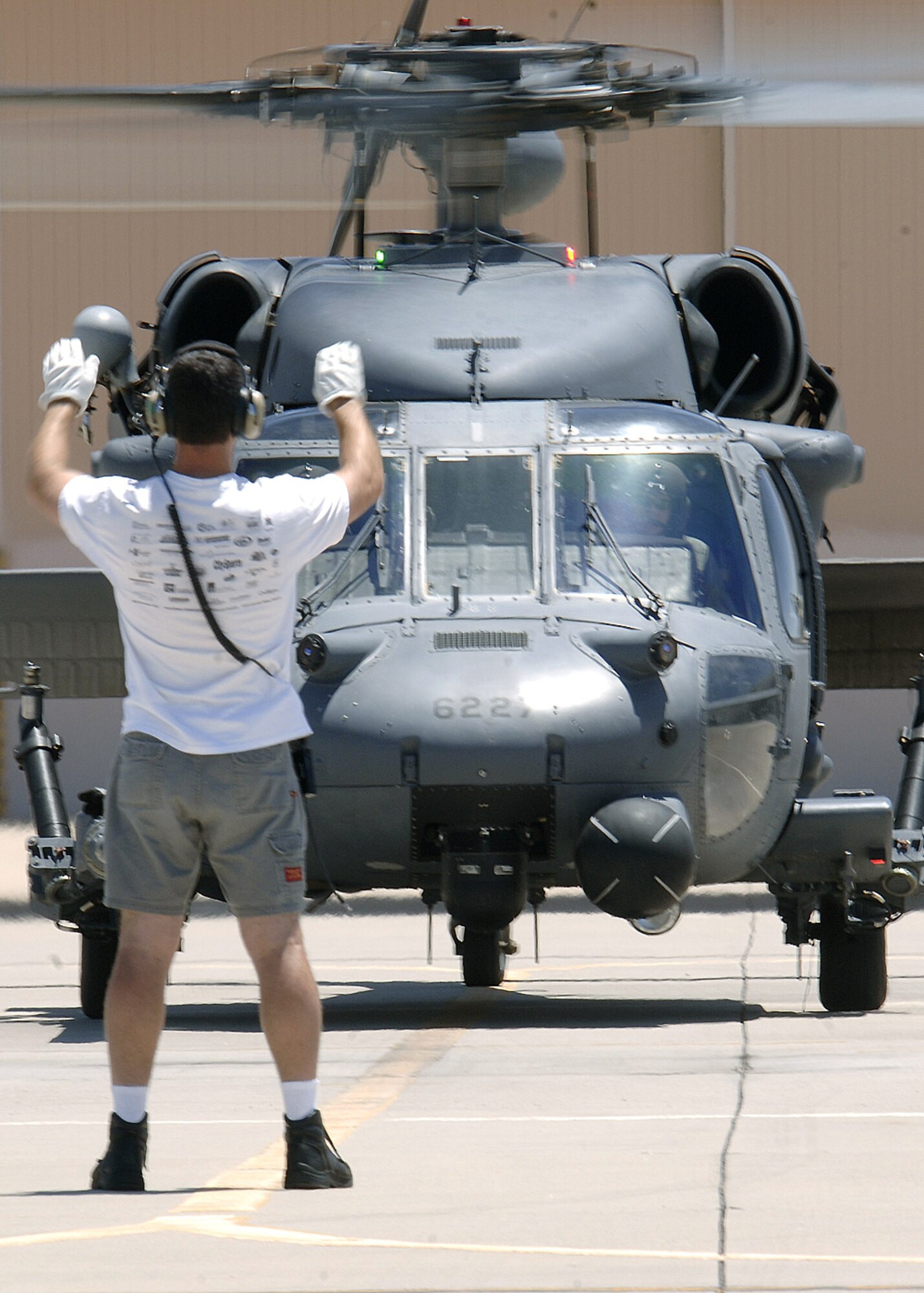 Tech. Sgt. Gregory Gaunt marshals an HH-60 Pave Hawk with Maj. John Keeler at the controls at Davis-Monthan Air Force Base, Ariz., on July 10. Major Keeler and Sergeant Guant were two of the Airmen who participated in a real-world rescue of an individual from a cargo ship off the coast of California on July 1. They are assigned to the Air Force Reserve Command's 943rd Rescue Squadron. (U.S Air Force photo/Senior Airman Christina D. Ponte)