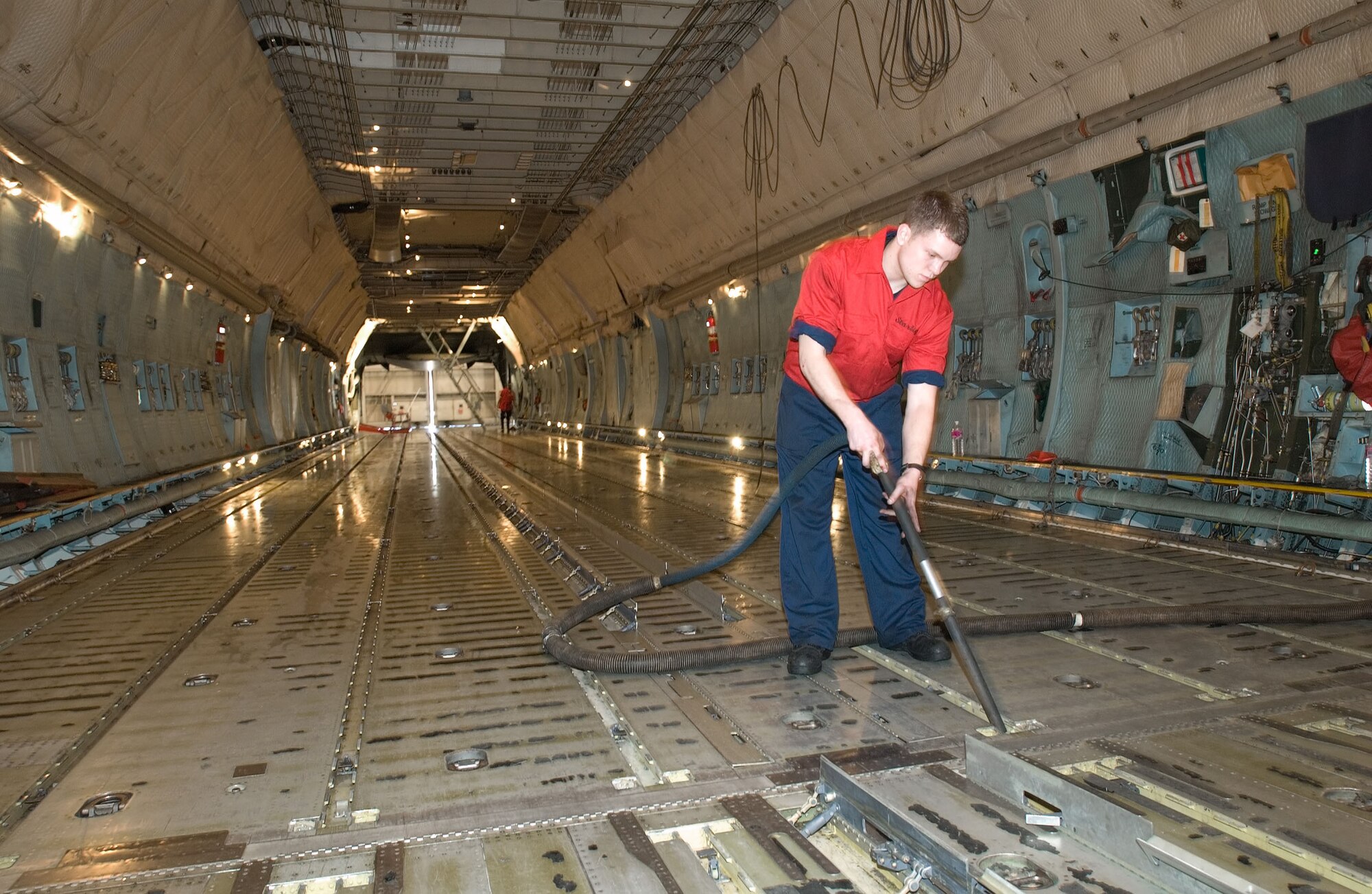 Mike LePore, Starlight Corporation aircraft servicer, vacuums water from the C-5 cargo compartment so it won’t corrode the cargo logistics rails.The military contractor is responsible for cleaning Dover Air Force Base's more than 25 C-5 Model B Galaxy aircraft. The wash process helps extend the life cycle of the plane.

