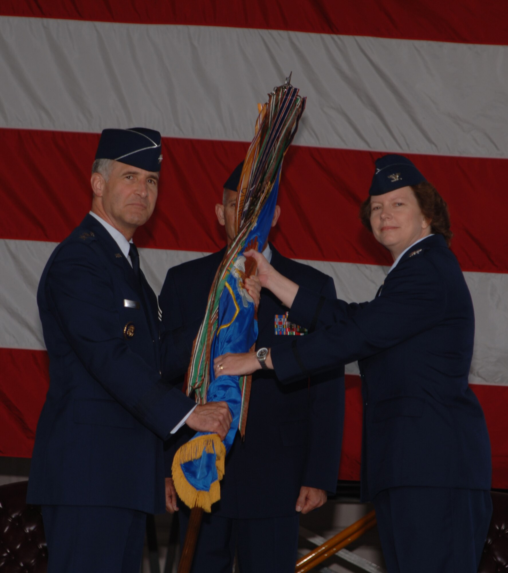 Maj. Gen. James Hawkins, 18th AF commander passes the 319th Air Refueling Wing guideon to its new commander Col. Diane Hull during a change of command cermony July 11.