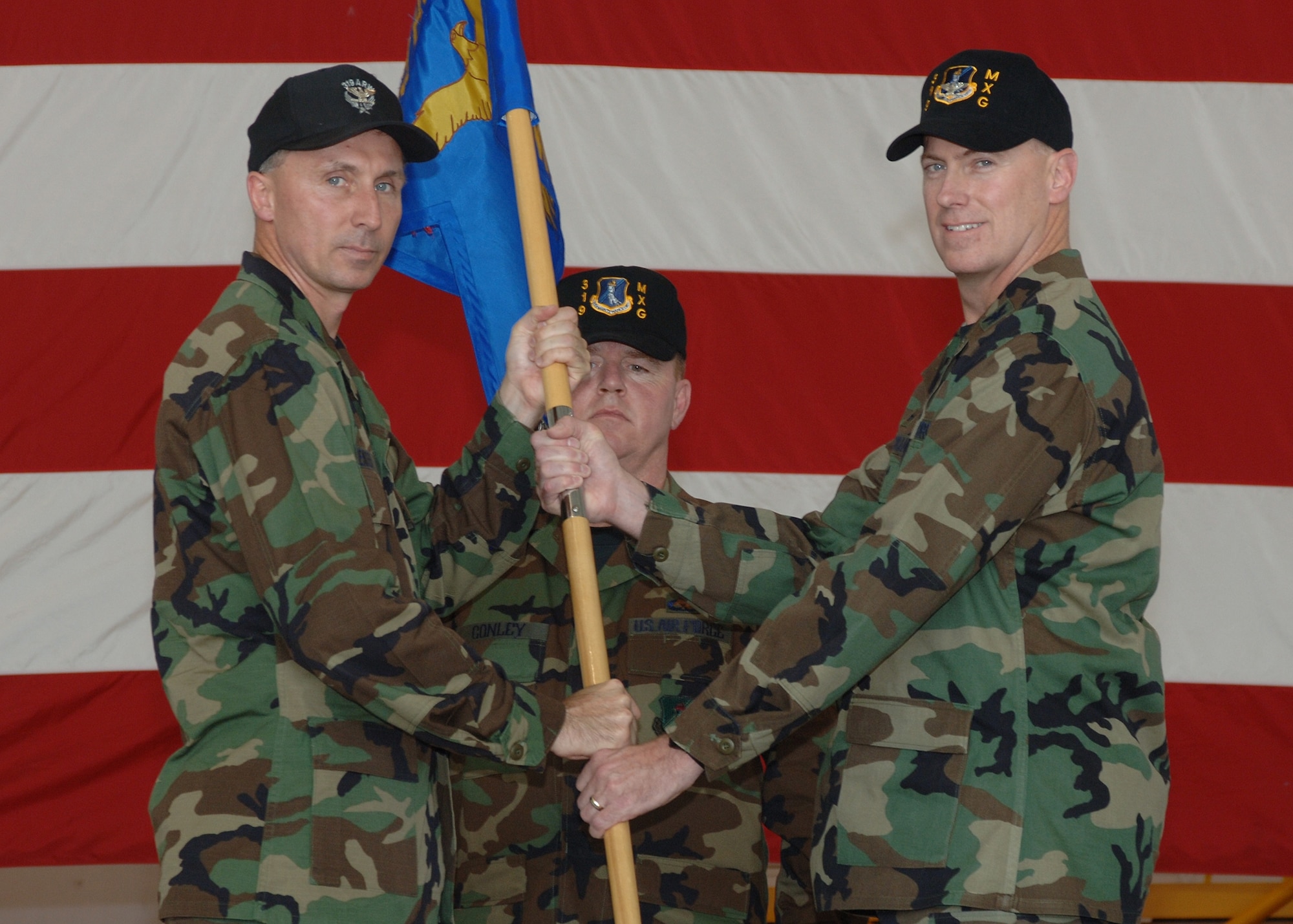 Col. Bill Bender, former 319th Air Refueling Wing commander, passes the Maintenance Group guidon to its new commander, Col. Raymond Corcoran July 6. (Photo by Airman 1st Class SerMae Lampkin)