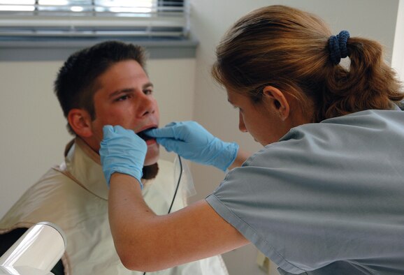 Dominika Pawlikowska, a Philadelphia dental hygienist with the FEDS_HEAL program, prepares Senior Airman Blake Bufogle, 512th Aircraft Maintenance Squadron crew chief, for dental X-rays. The X-ray machine, connected to a computer, takes a dental X-ray, transmits it to the computer and it is printed for reservists. The Federal Strategic Health Alliance is a partnership between the Federal Occupational Health, Veterans Health Administration and a network of private providers. Their goal is to equip reservists with improved access to medical services.