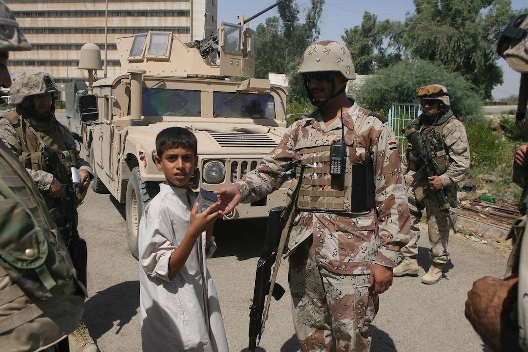 On July 14th, an Iraqi Soldier hands an Iraqi child a brand new watch during a security patrol. Soldiers from the 2nd Battalion, 1st Brigade, 7th Iraqi Army Division led a security patrol outside Combat Operation Post Hawk as Marines with Company I, 3rd Bn., 8th Marines followed. The operation was conducted to get a feel for the surrounding community and to hand out water to residents living nearby the Ramadi Hospital. 3/8 is currently deployed with I MEF (FWD) in support of Operation Iraqi Freedom in the Al Anbar province of Iraq (MNF-W) to develop the Iraqi Security Forces, facilitate the development of official rule of law through demographic government reforms, and continue the development of a market based economy centered on Iraqi reconstruction.   USMC photo by Cpl. Joseph DiGirolamo  060714-M-0008D-029