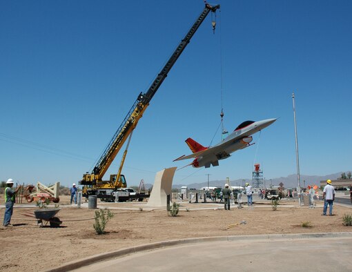 Contractors lift an F-16 painted in World War II Tuskegee colors July 11, 2006. The F-16 will become a static display in front of the 944th Fighter Wing headquarters and is scheduled to be unveiled during a dedication ceremony Aug. 2. (U.S. Air Force photo/Staff Sgt. Susan Stout)