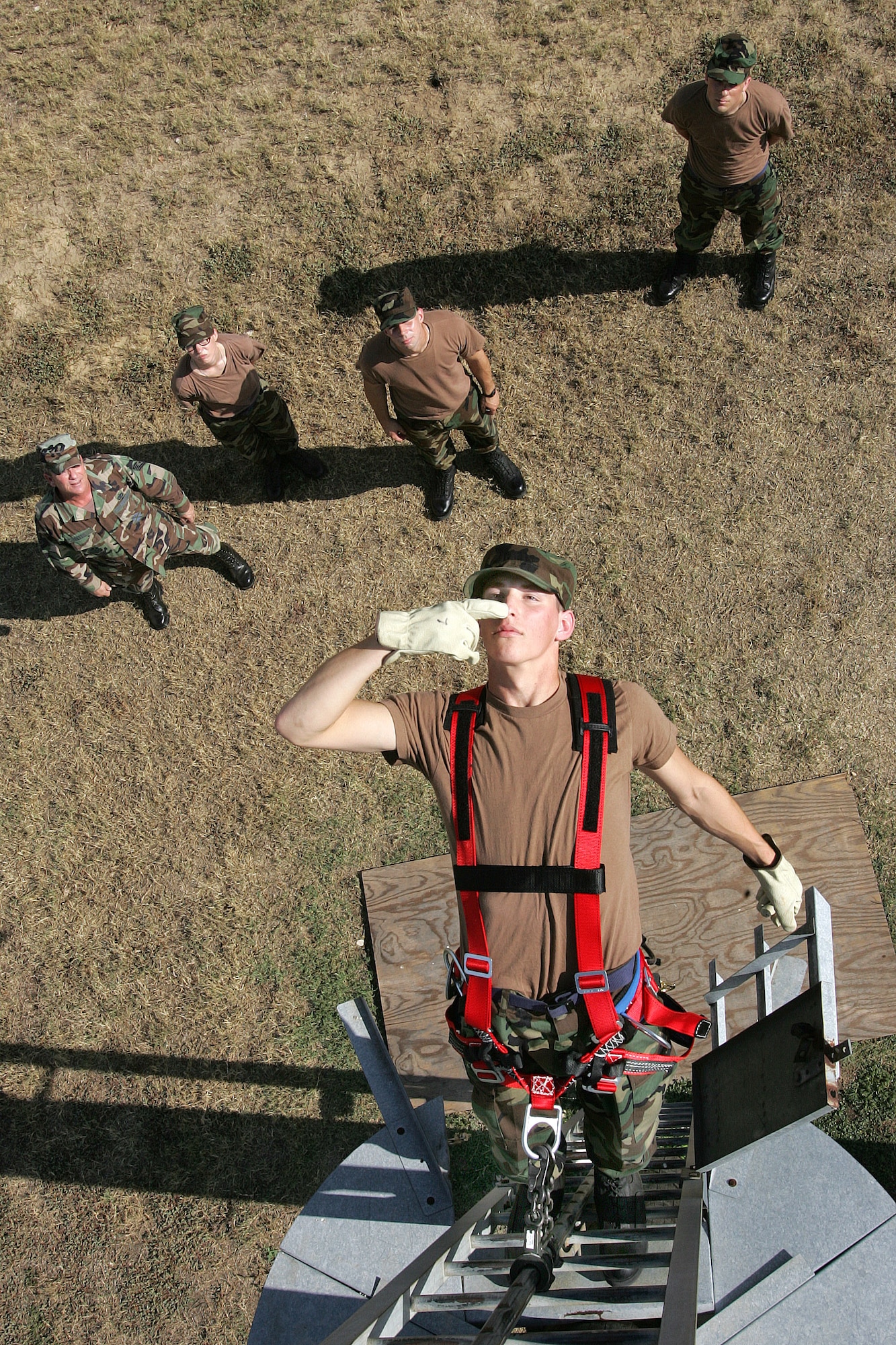 During an evaluation for acrophobia, Airman Basic James Pelletier touches his nose as he performs a test of balance atop a ladder attached to a utility pole at Lackland Air Force Base, Texas, on Thursday, July 13. Airman Pelletier has been selected for the communications career field, one of six Air Force career fields requiring the evaluation on the fear of heights before continuing to technical school. Airman Pelletier, in his second week of basic training, is assigned to the 322nd Training Squadron. (U.S. Air Force photo/Robbin Cresswell)