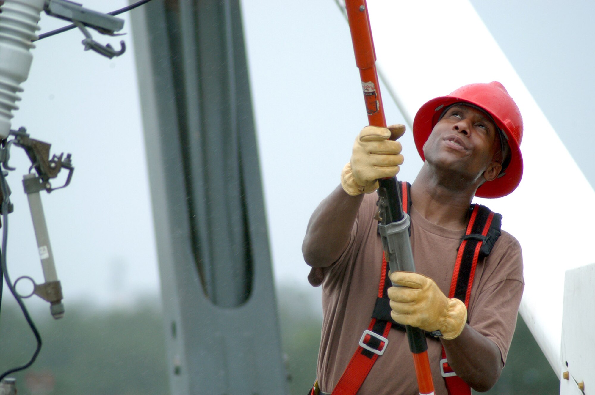 Tech. Sgt. Jeffrey Dickson repairs a utility pole outside the wing headquarters while braving the remnants of Typhoon Ewiniar at Kunsan Air Base, South Korea, on July 10. Kunsan was spared the wrath of the typhoon as it was downgraded to a tropical storm before entering the cooler waters around the Korean peninsula. Sergeant Dickson is an electrical systems craftsman with the 8th Civil Engineer Squadron. (Air Force photo/Staff Sgt. Nathan Gallahan) 
