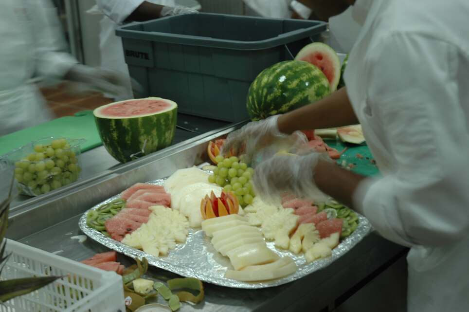 A third country national, employed by the dining facility, prepares a cold cut platter at the new DFAC at Al Asad, Iraq, July 16. The new DFAC was constructed to meet the demands of the growing air base. With a larger seating area the new DFAC will be able to facilitate more than 2,000 patrons.