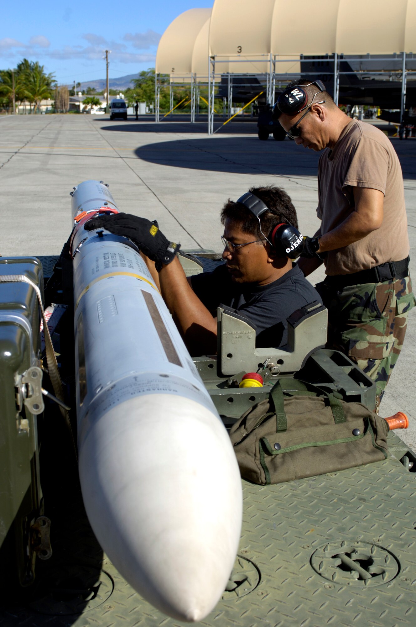 HICKAM AIR FORCE BASE, Hawaii -- Master Sgt. Baldwin Ojerio and Staff Sgt. Arthur Hamabata inspect an AIM-7 Sparrow missile before loading it on an F-15 Eagle at Hickam Air Force Base Hawaii July 16, 2006 during Rim of the Pacific Exercise 2006. The Airmen are from the Hawaii Air National Guard 154th Aircraft Maintenance Squadron. The Eagles will be firing 14 live missiles at two decoy targets during RIMPAC. RIMPAC 2006 brings friendly forces from the Pacific theater and the United Kingdom together to engage in air and sea war games. (U.S. Air Force photo/ Tech. Sgt. Shane A. Cuomo)