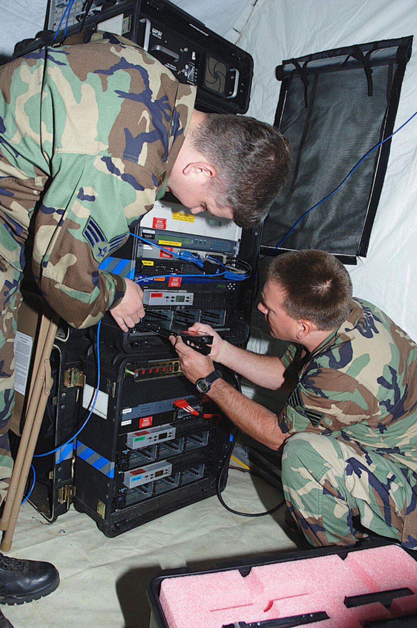 Senior Airman Phillip Hess, standing, 35th Combat Communications Squadron, helps a student install a hard drive in a driver during JUMP START 06 Training Exercises held at Tinker Air Force Base, Okla.