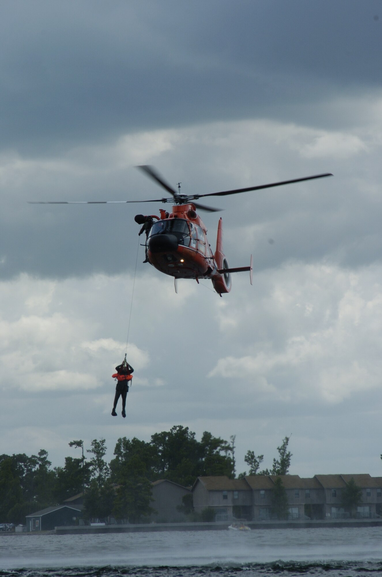 An aircrew member from the 317 AS gets picked up by a Coast Guard helicopter during aircrew survival training.  Pilots and loadmasters from the 315th Operations Group, Charleston AFB, S.C. participated in the one-day event that also included combat survival training. The group went through how to escape, evade and survive, what can be eaten in this situation, how the equipment can be used, and more survival tips. (Photo by Maj. Mark Johnson, USAFR)