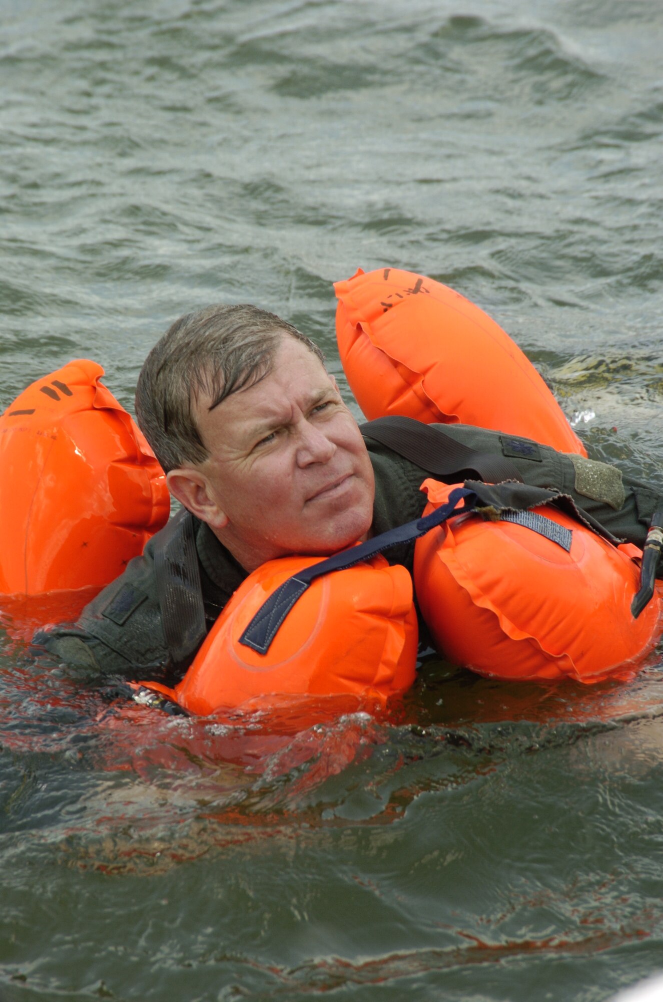 Lt. Col. Rick Davis, 317 AS pilot, waits to be picked up by a Coast Guard helicopter during aircrew survival training.  Pilots and loadmasters from the 315th Operations Group, Charleston AFB, S.C. participated in the one-day event that also included combat survival training. The group went through how to escape, evade and survive, what can be eaten in this situation, how the equipment can be used, and more survival tips. (Photo by Maj. Mark Johnson, USAFR)