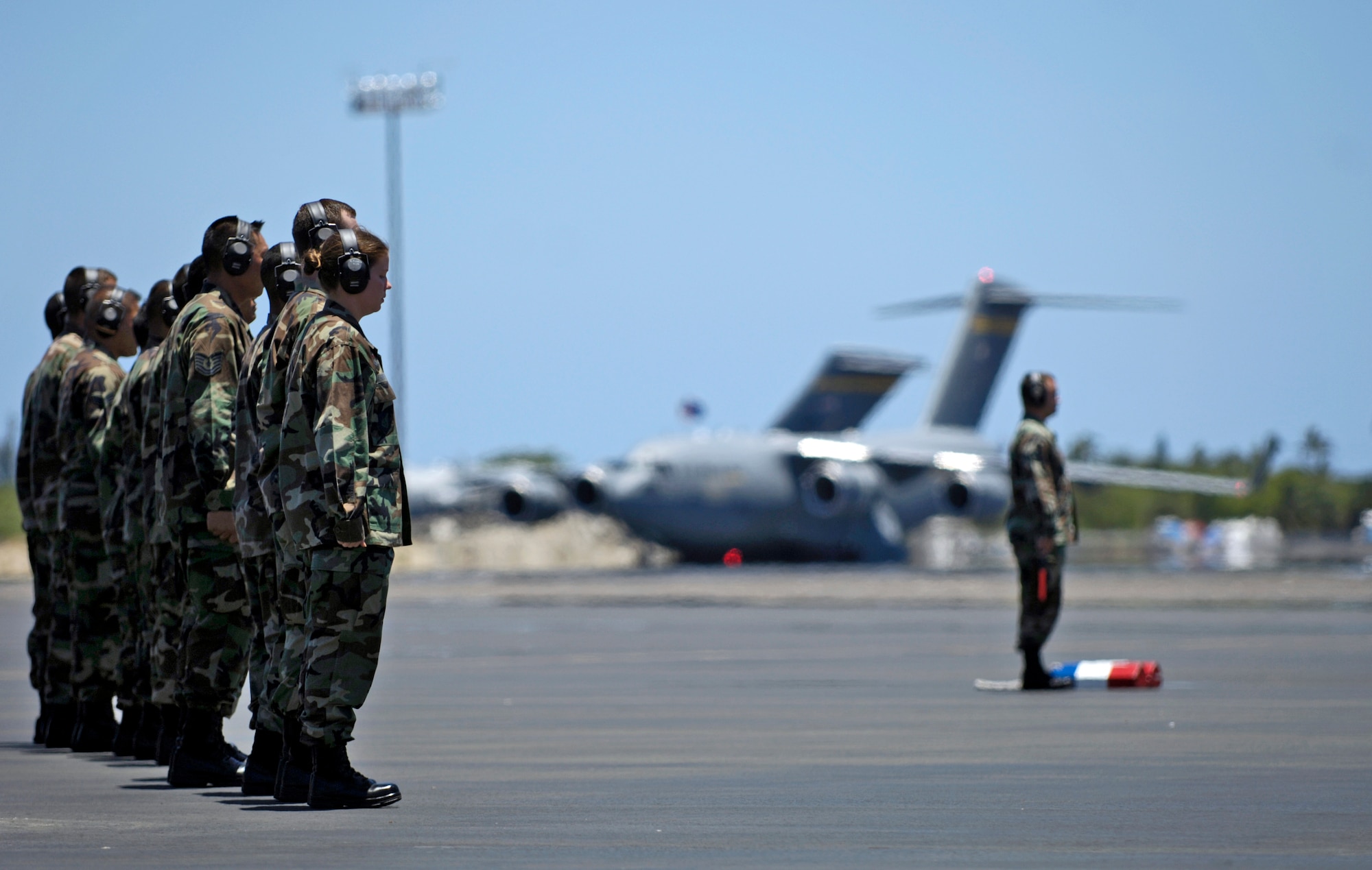 Aircraft maintainers stand at attention while waiting for a C-17 Globemaster III to taxi to its parking spot at Hickam Air Force Base, Hawaii, on July 18.  The "Spirit of Kamehameha- Imua" is the eighth and final C-17 for the 15th Airlift Wing at Hickam. It marks the successful transformation for the 15th AW from a support unit to an operational strategic airlift wing. The maintainers are active duty Airmen and Hawaii Air National Guardsmen. (U.S. Air Force photo/Tech. Sgt. Shane A. Cuomo)