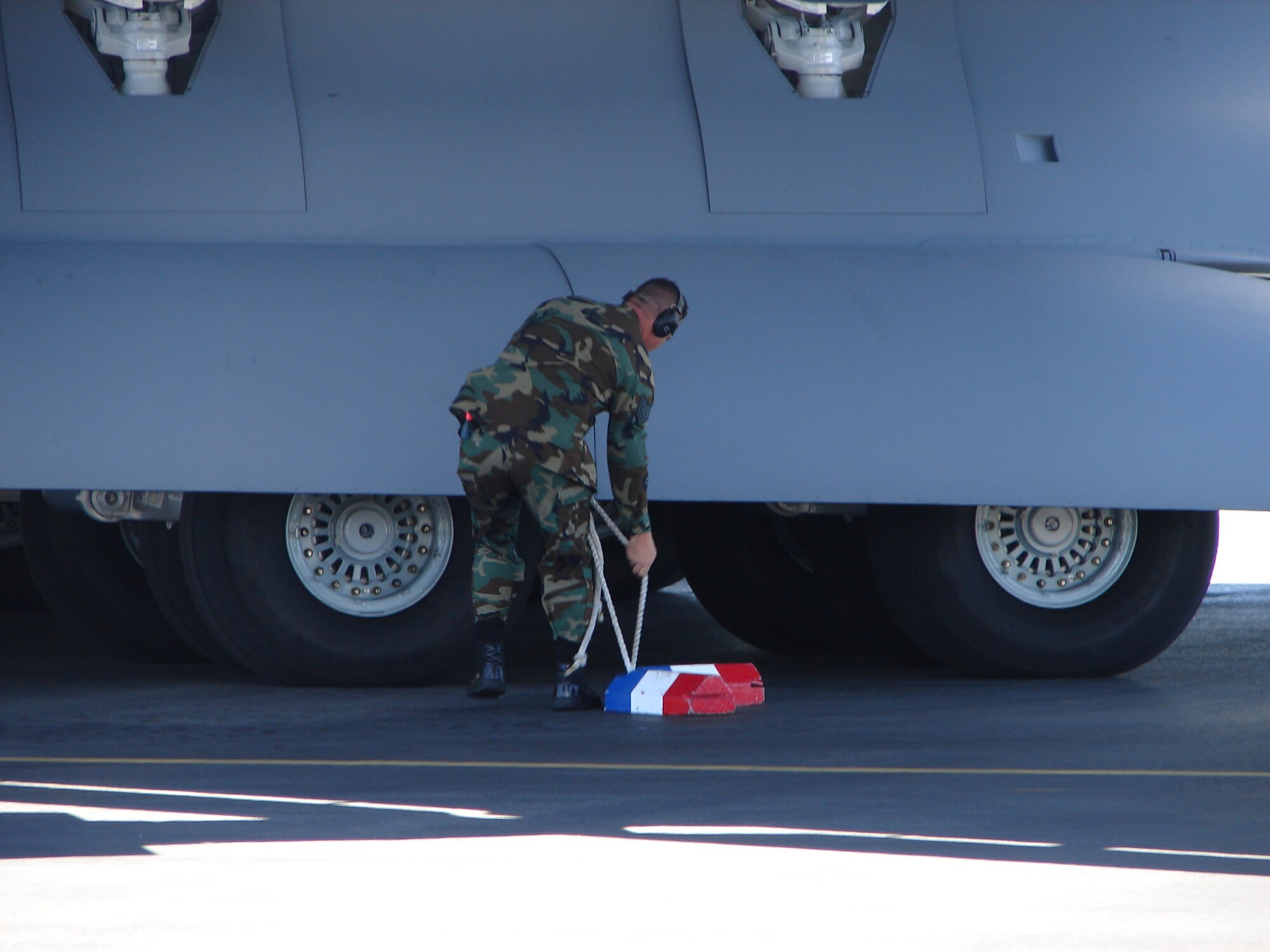 HICKAM AIR FORCE BASE, Hawaii – An airmen from Team Hickam secures the wheels of Hickam's last of eight C-17 Globemaster III, which arrived today. The arrival of The Spirit of Kamehameha – Imua completes the successful transformation of the 15th Airlift Wing from a support unit to an operational strategic airlift wing.  (Air Force photo by Major Brad Jessmer)
