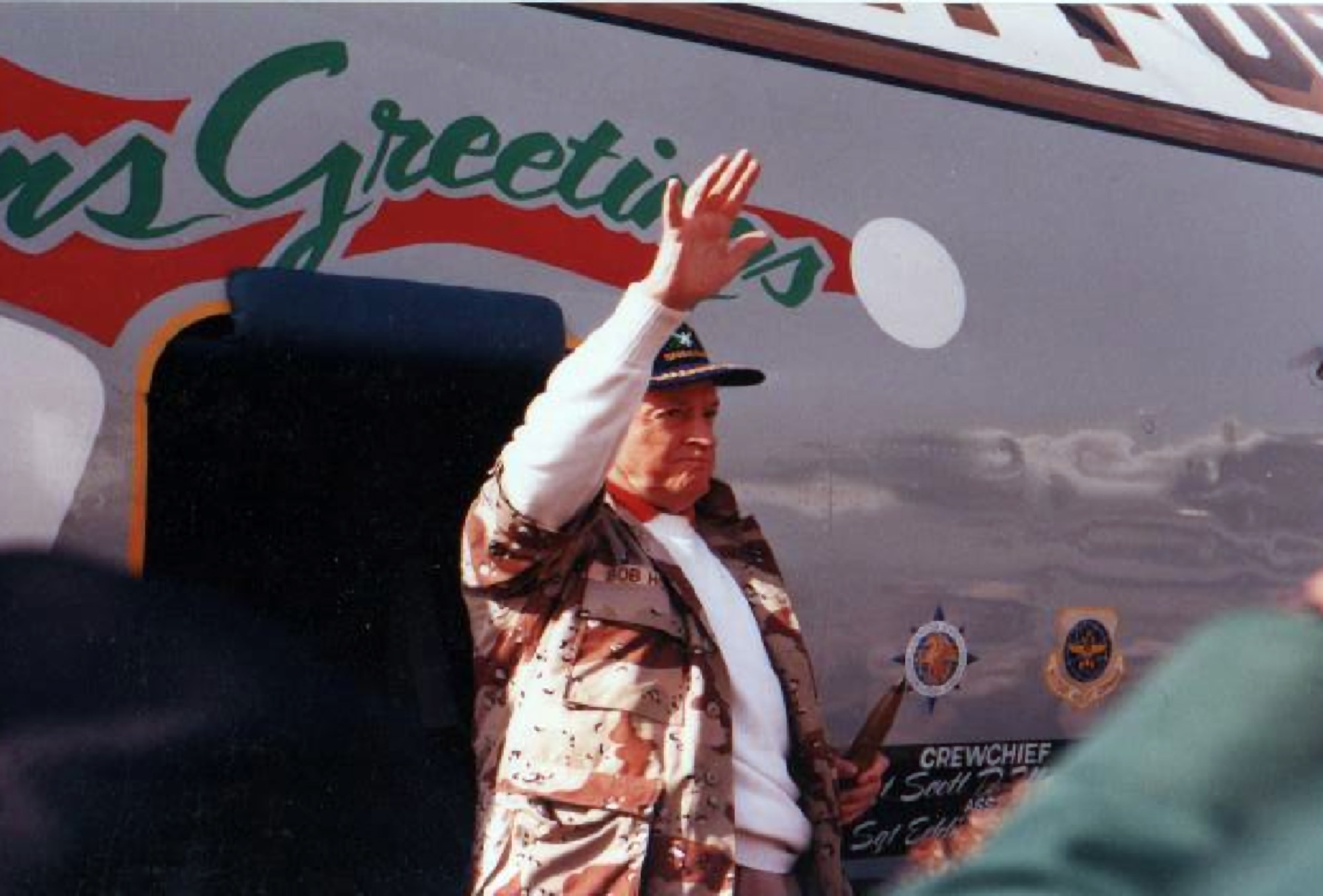 Bob Hope waves to the crowd seeing him off at an air base in Southwest Asia on Christmas Day 1990. (U.S. Air Force photo by William Scott Hubbartt-Backus)