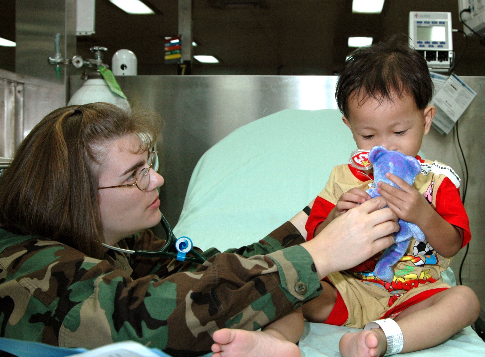 Maj. Gretchen Black presents a gift to a young patient aboard the U.S. Navy hospital ship USNS Mercy while at a stop in Nias Island, Indonesia, on July 17. The Mercy is in the third month of a scheduled five-month deployment, conducting humanitarian and civic assistance in South and Southeast Asia and the Pacific Islands. Major Black is one of several Air Force medical professionals on the ship. (U.S. Navy photo/Seaman Joseph Caballero)
