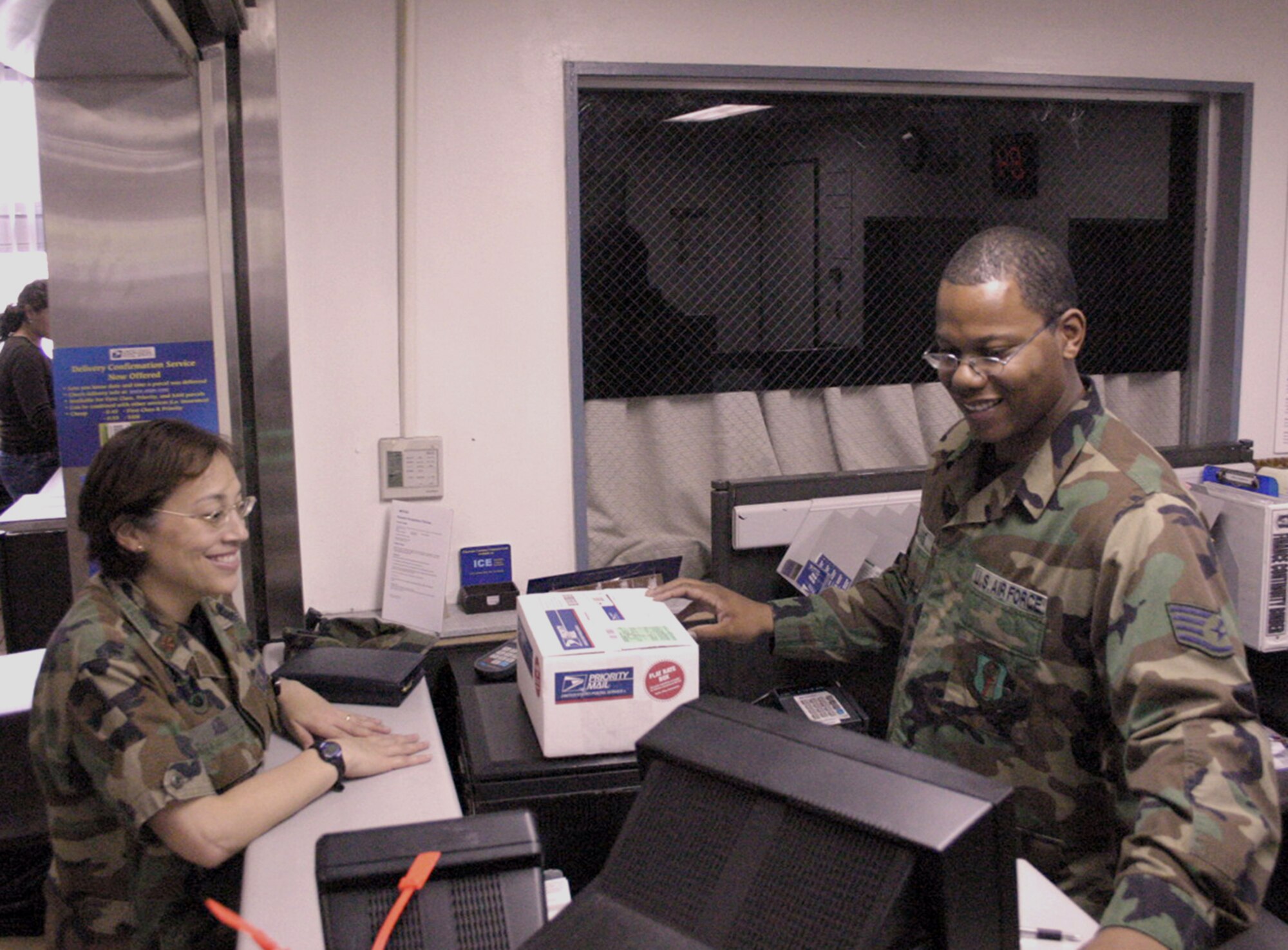 MISAWA AIR BASE, Japan -- A customer at the post office here, Maj. Regina Agee (left), is helped at the service counter by Staff Sgt. Jason Williams, 35th Communications Squadron finance postal clerk, who ensures that all packages are properly addressed and weighed. Friendly customer service contributed to Misawa winning the award for the best large postal facility in the Air Force.  (Air Force photo coutesy of 35th Fighter Wing Public Affairs)