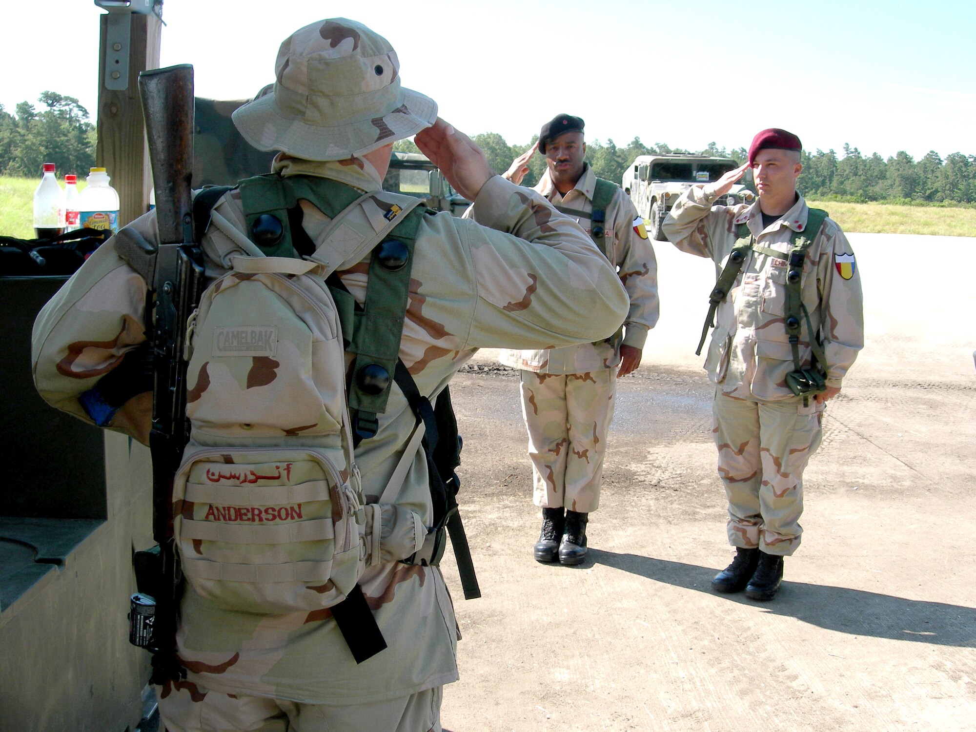 Airmen serving as role players in a foreign national army salute each other during an Exercise Eagle Flag 06-3 scenario at Naval Air Engineering Station Lakehurst, N.J., on July 14. The exercise tests Airmen on their expeditionary combat support skills. Training is conducted by the Air Mobility Warfare Center's 421st Combat Training Squadron staff at Fort Dix, N.J. (U.S. Air Force photo/Tom Fuller)