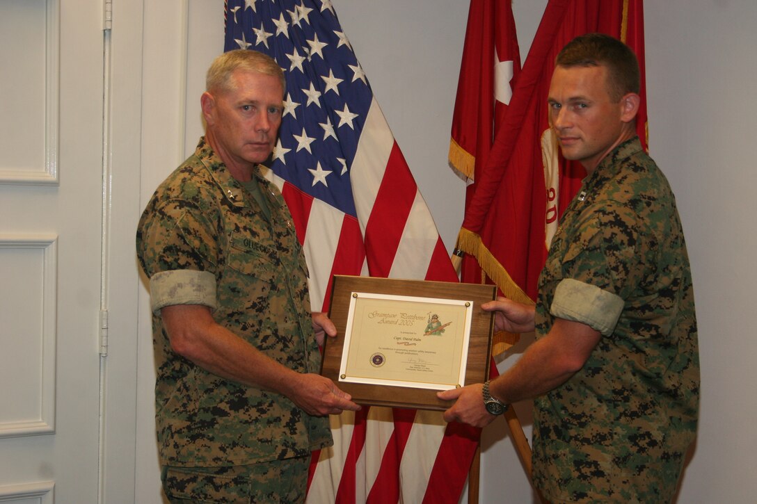 Maj. Gen. Kenneth J. Glueck Jr., commanding general of 2nd Marine Aircraft Wing, shakes hands with Capt. David Palm during his award ceremony, July 18.