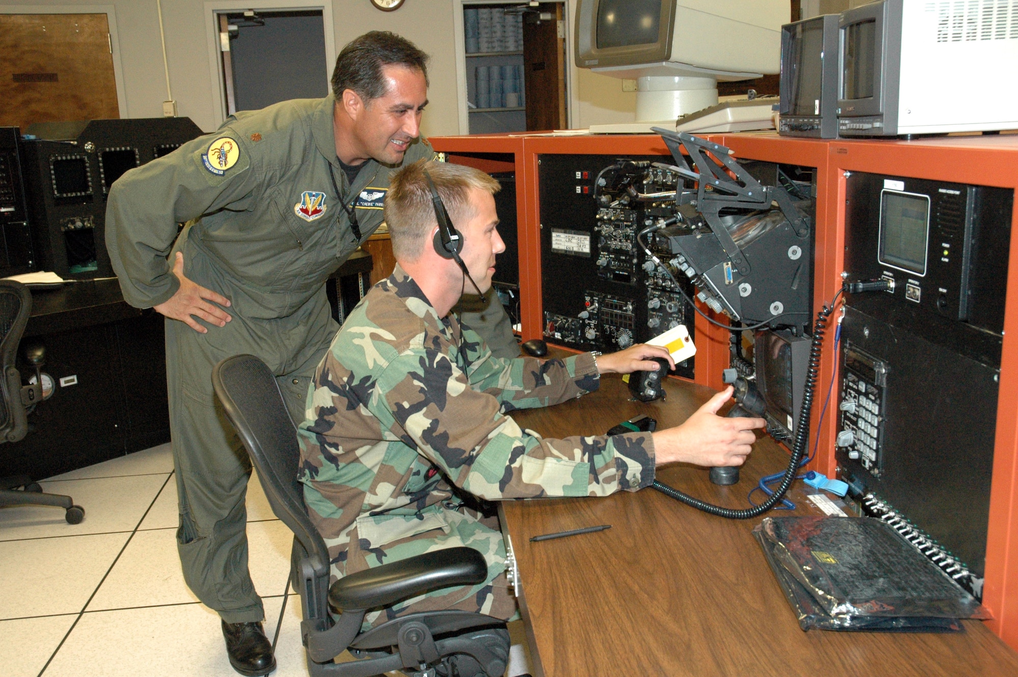 Maj. Raul Parra watches 2nd Lt. Will Dalton, an F-15 Eagle avionics engineer, operate the F-15C console at Tyndall Air Force Base, Fla. Major Parra is director of operations at the Integrated Avionics Test Facility of Detachment 2, 28th Test and Evaluation Squadron. (U.S. Air Force photo)
