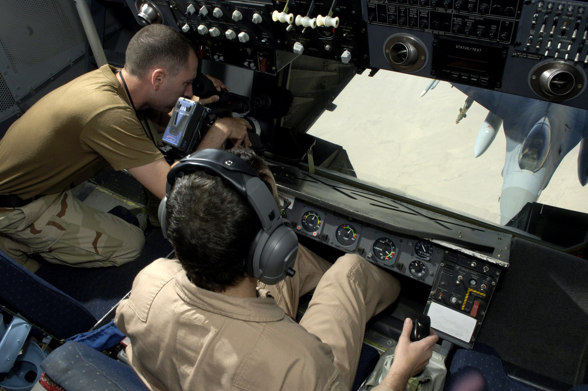 Master Sgt. Todd McPeak refuels an F-16 Fighting Falcon while Staff Sgt. Trevor Pedro films the mission on July 18. Sergeant McPeak is a KC-10 Extender boom operator for the 908th Expeditionary Air Refueling Squadron. Sergeant Pedro is a videographer for the U.S. Central Command Air Forces news team deployed to Southwest Asia. (U.S. Air Force photo/Senior Airman Brian Ferguson) 

