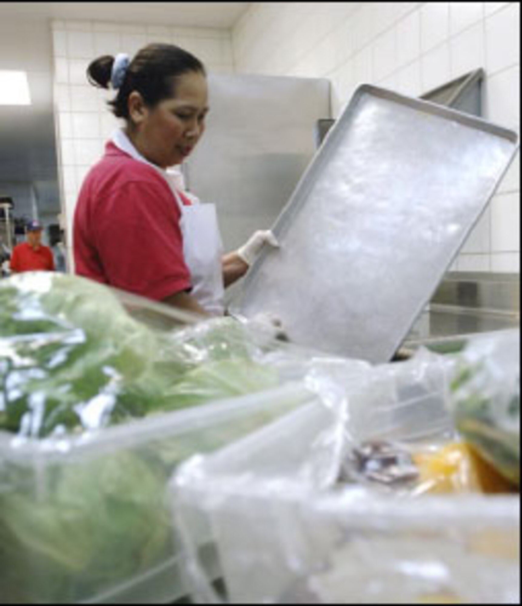 Kahmtan Greenlee, 22nd Services Squadron server, cleans a tray to arrange freshly sliced vegetables to serve at the salad bar. (U.S. Air Force photo/Master Sgt. Maurice Hessel)