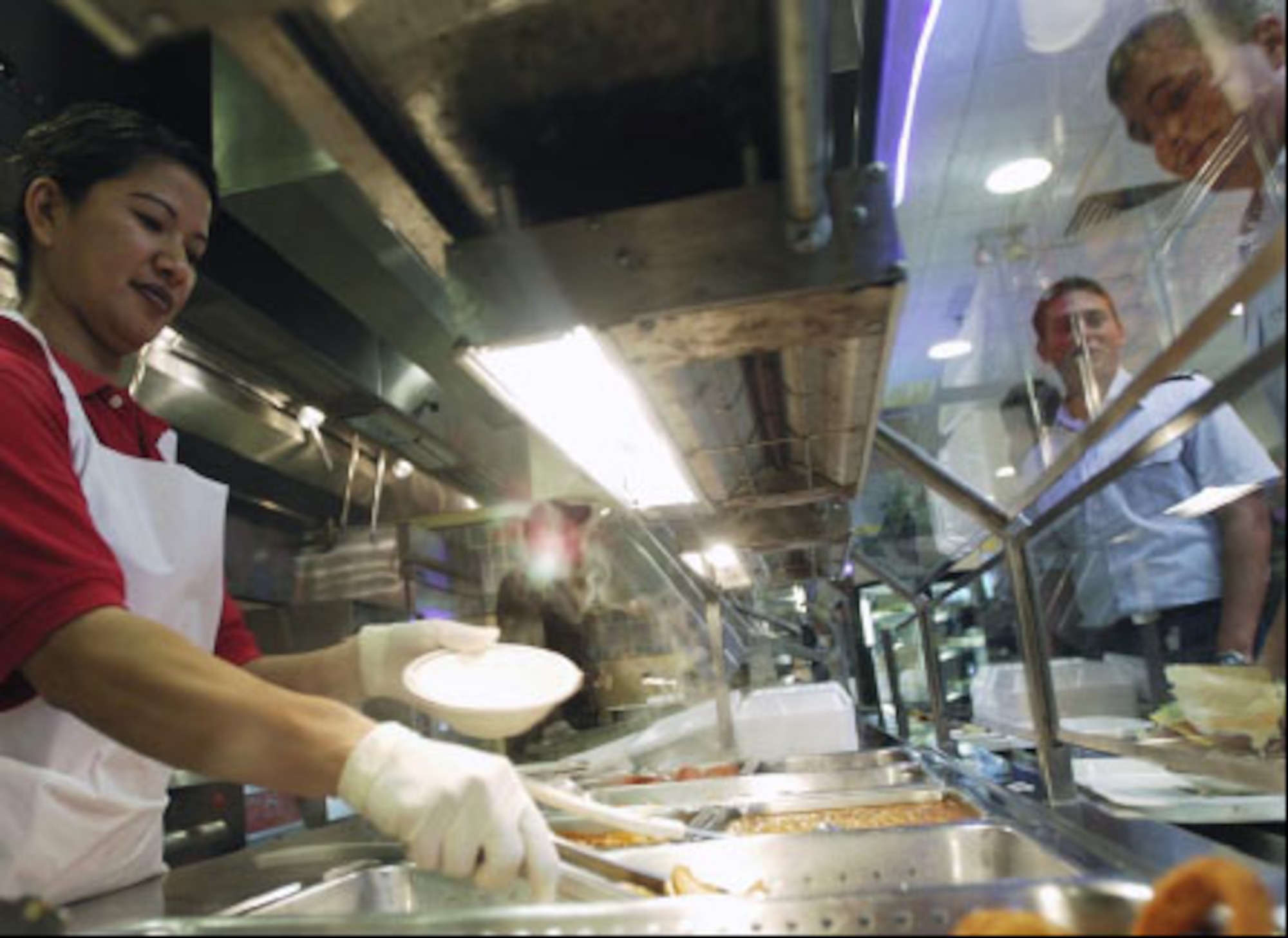 After a long morning of preparations and cooking, lunch is served. Hilda Castro, 22nd Services Squadron server, working the day shift, fills an Airman?s bowl with some scrumptious foods. (U.S. Air Force photo/Master Sgt. Maurice Hessel)